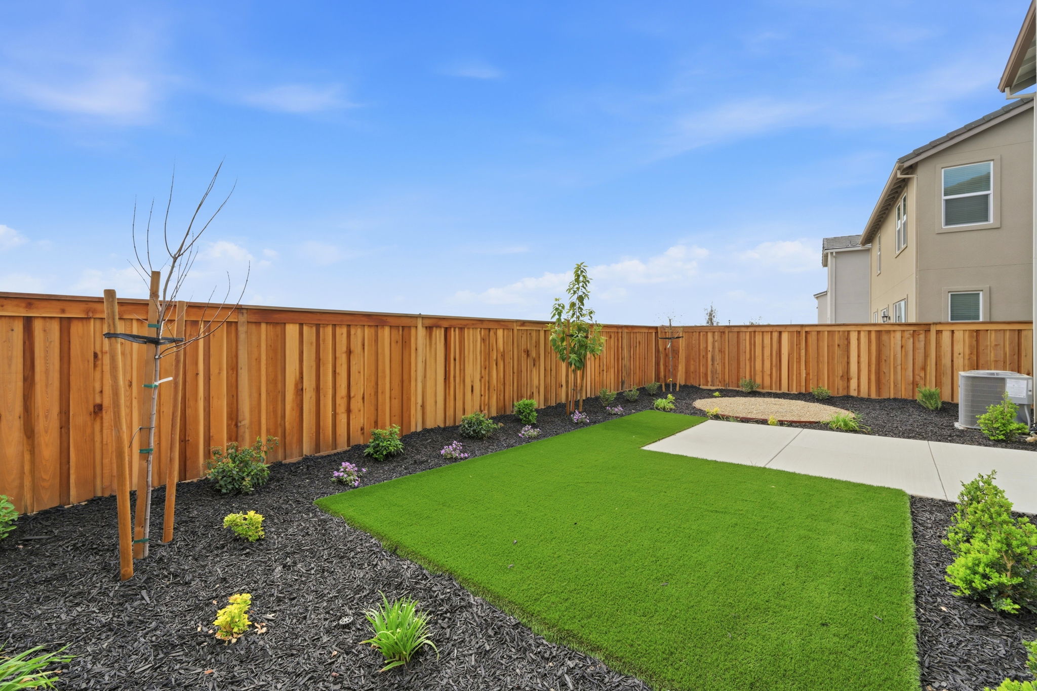 A backyard with a fence and a yard.