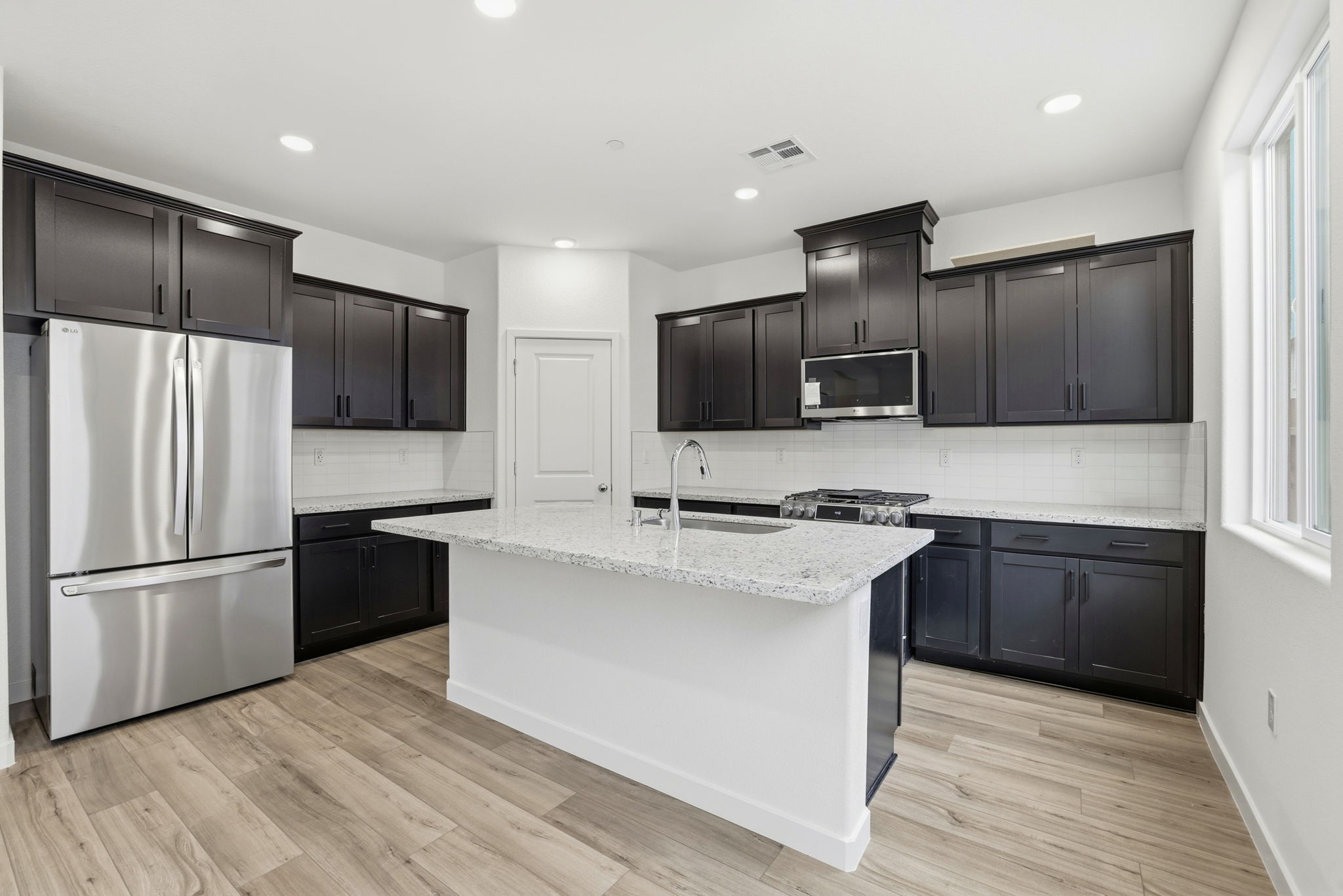A kitchen with black cabinets.