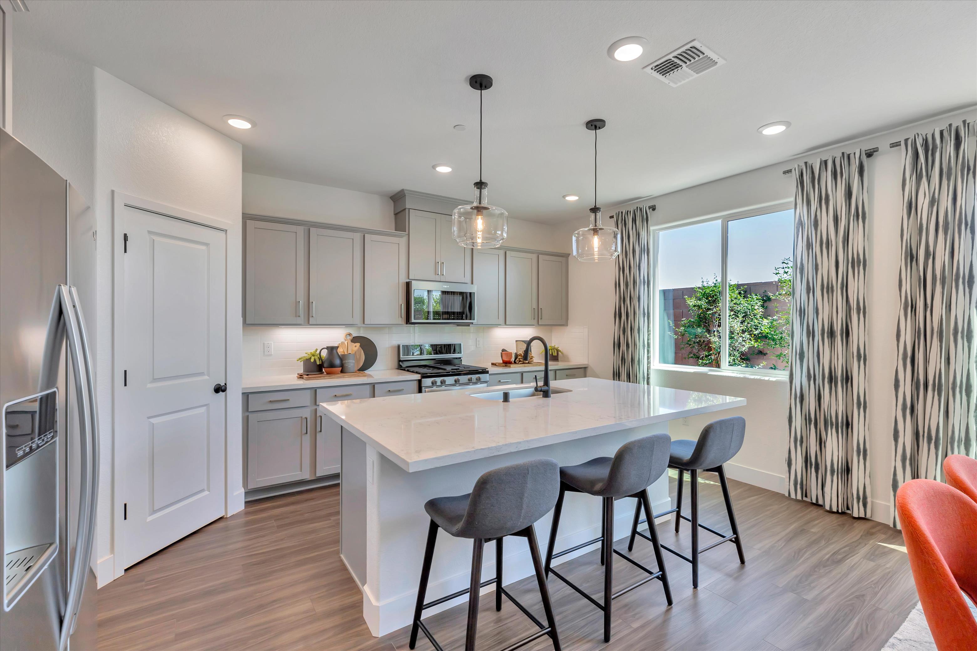 A kitchen with a bar stool and a table.