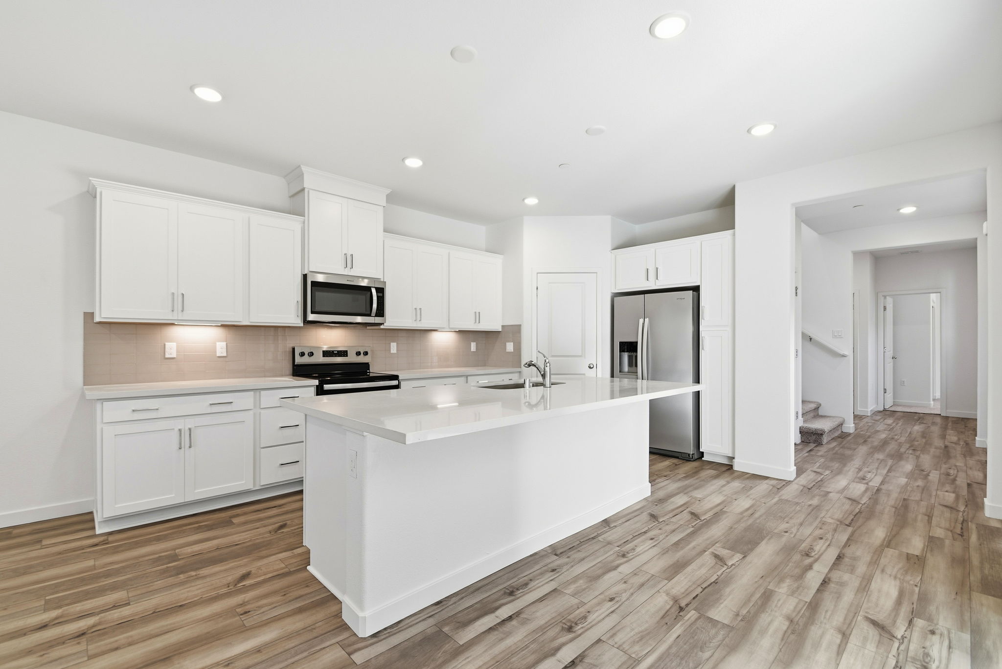 A kitchen with white cabinets.