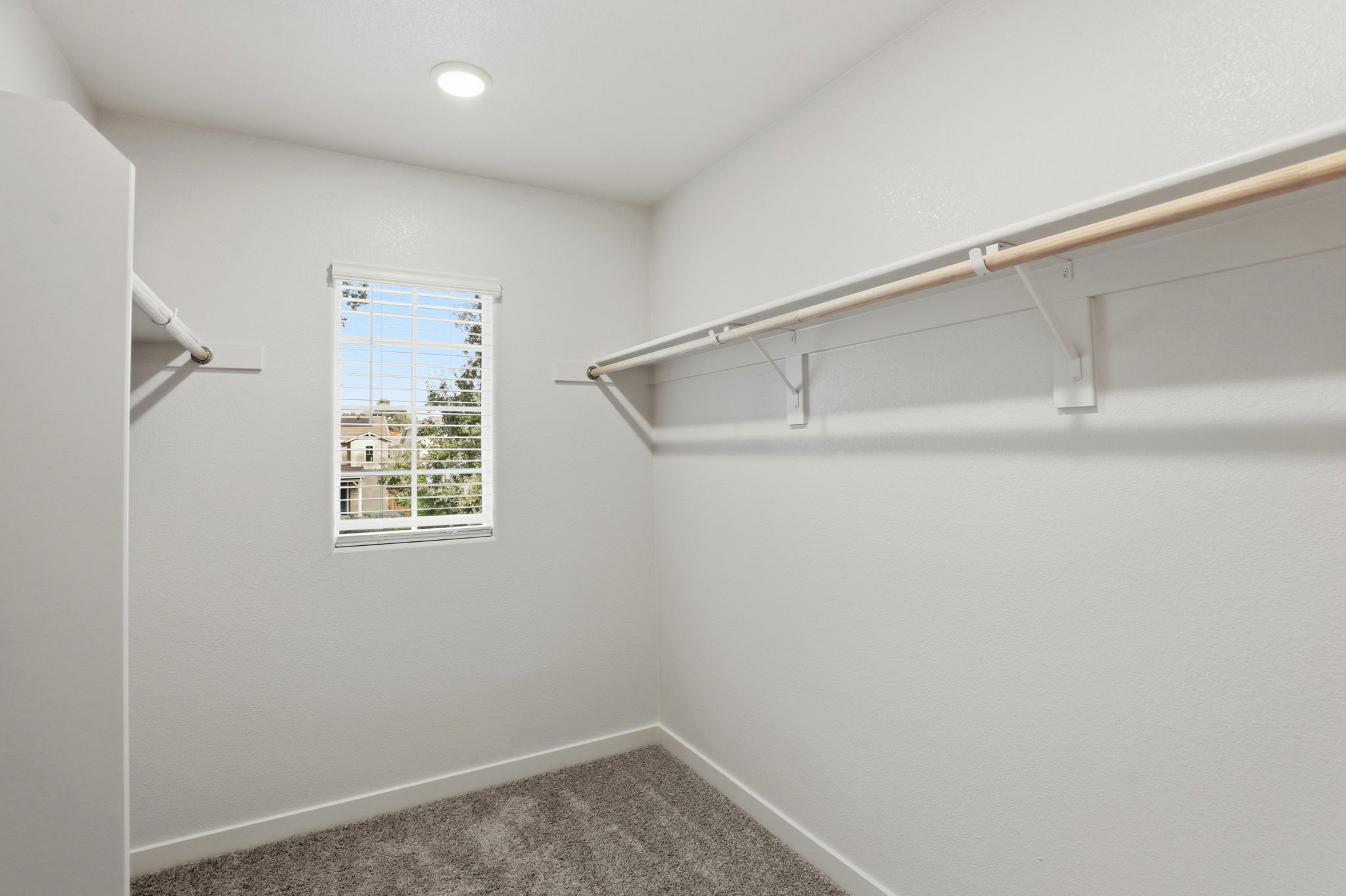 A room with a window and a metal bar.