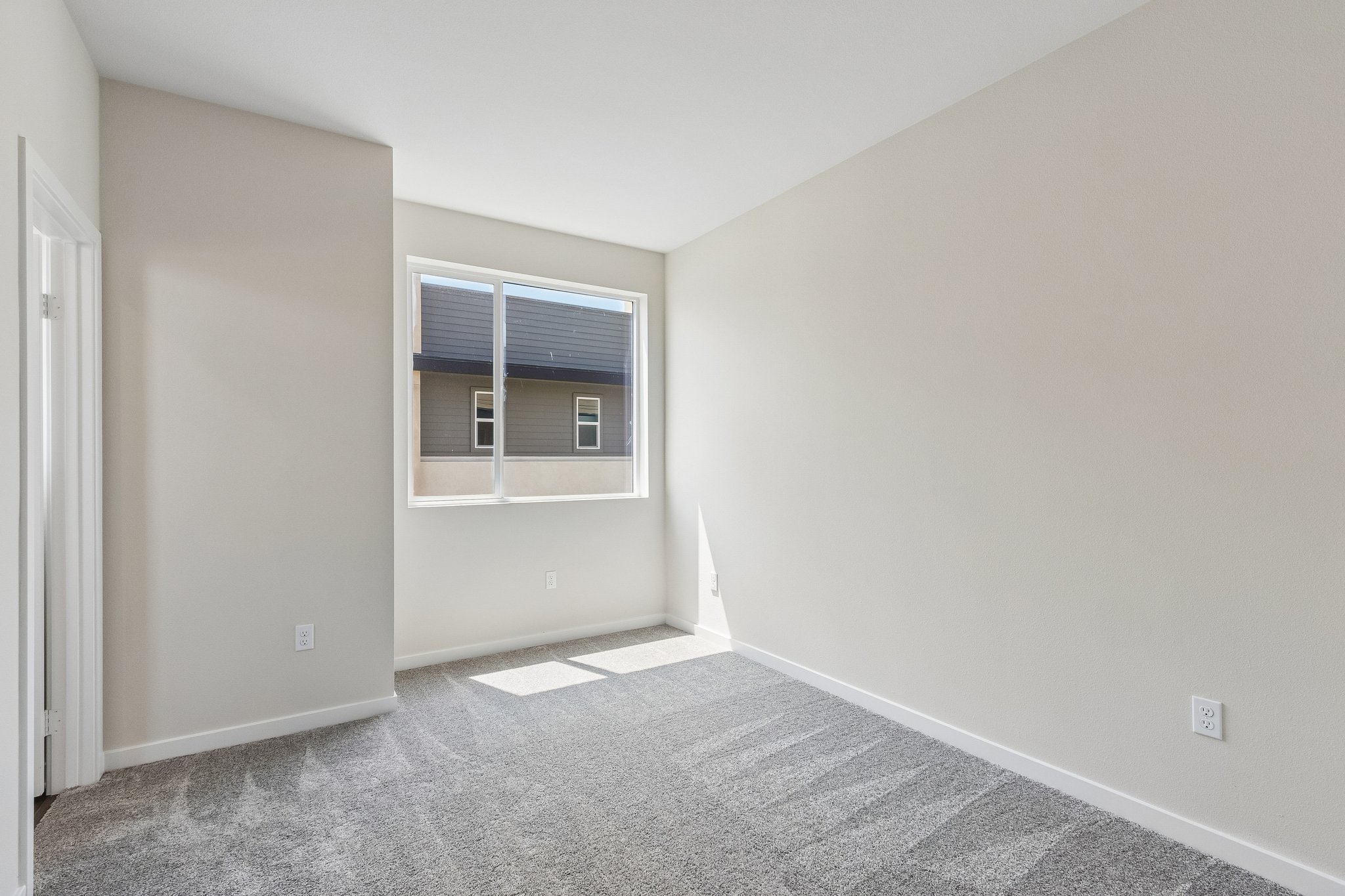 A room with a window and carpet.