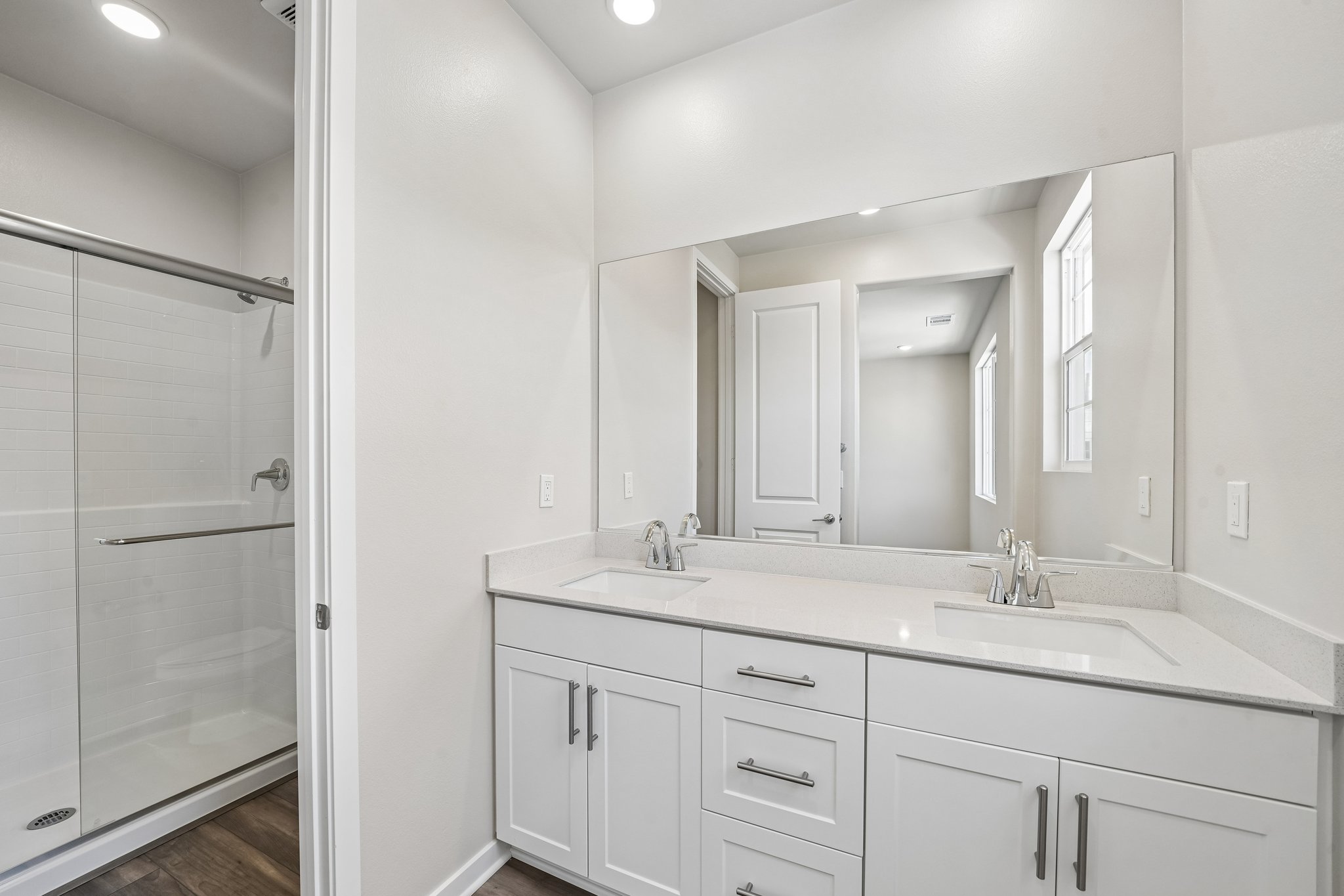 A bathroom with white cabinets.