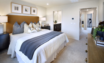 A bedroom with a bed and a mirror.
