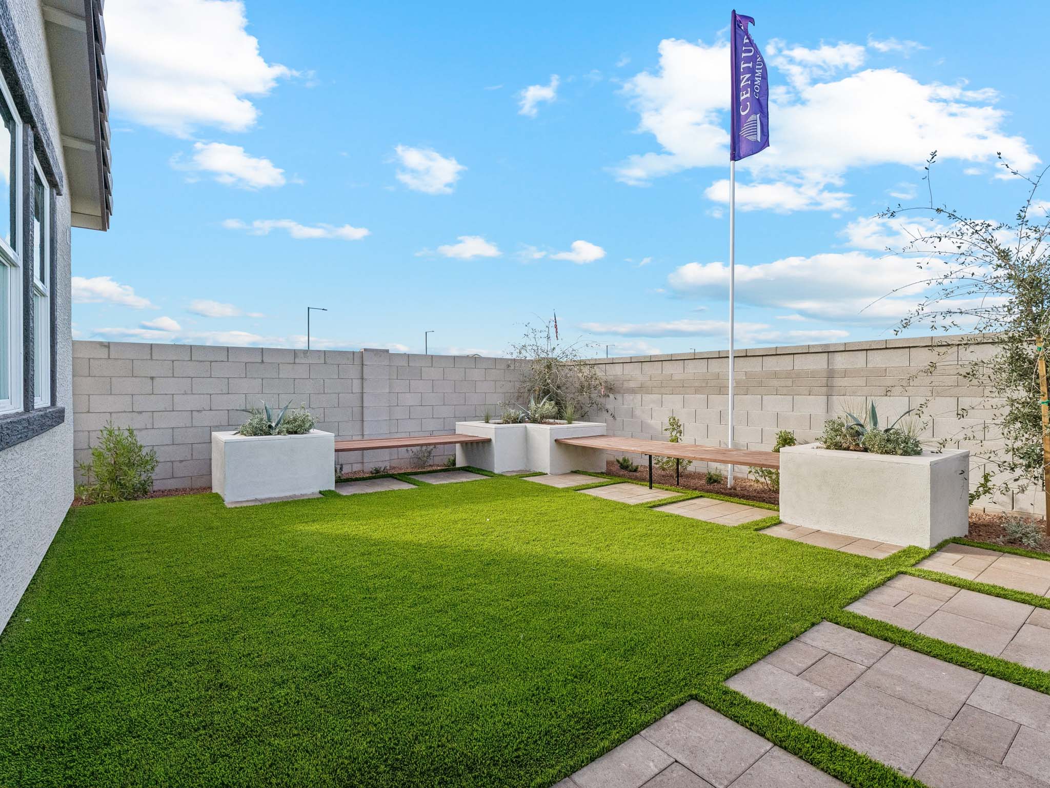 A flag on a pole in a grassy area next to a building.