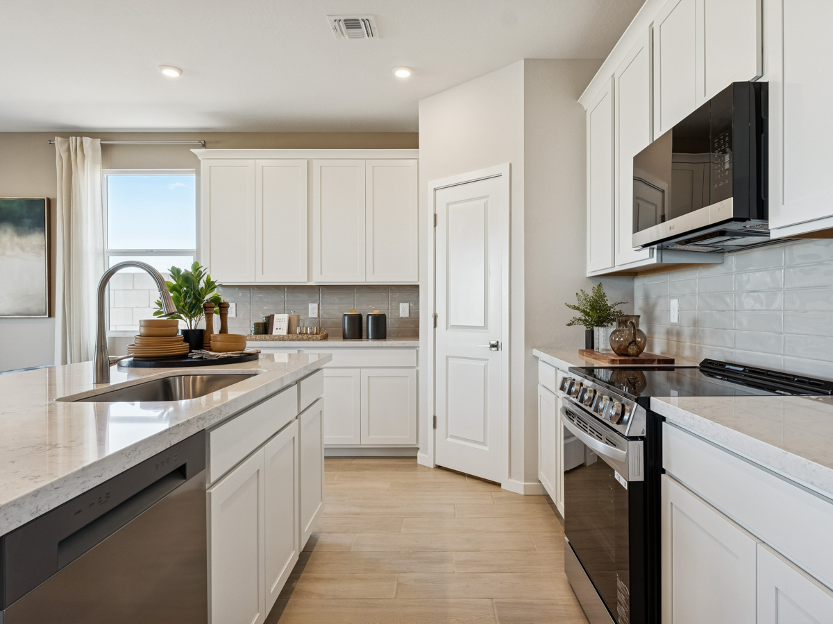 A kitchen with white cabinets.