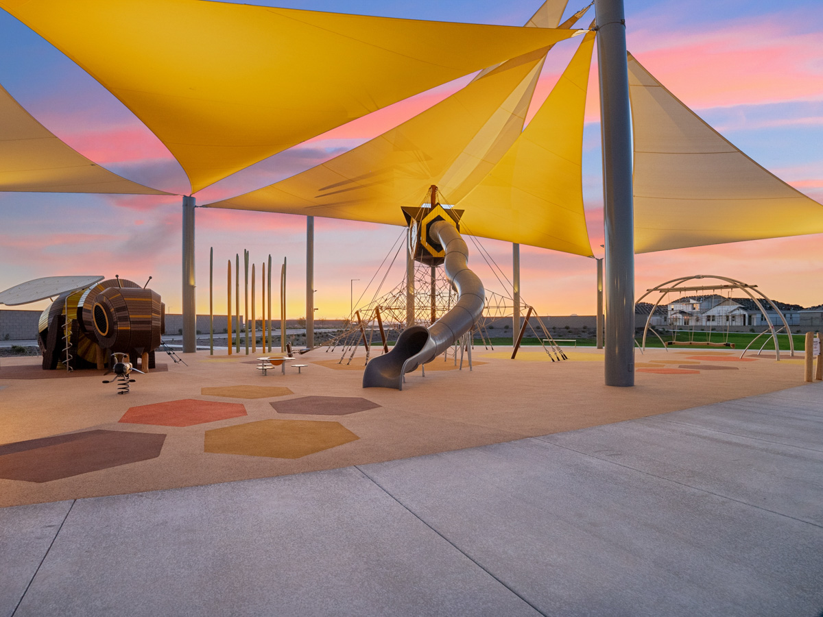 A statue of a bird under a colorful umbrella.