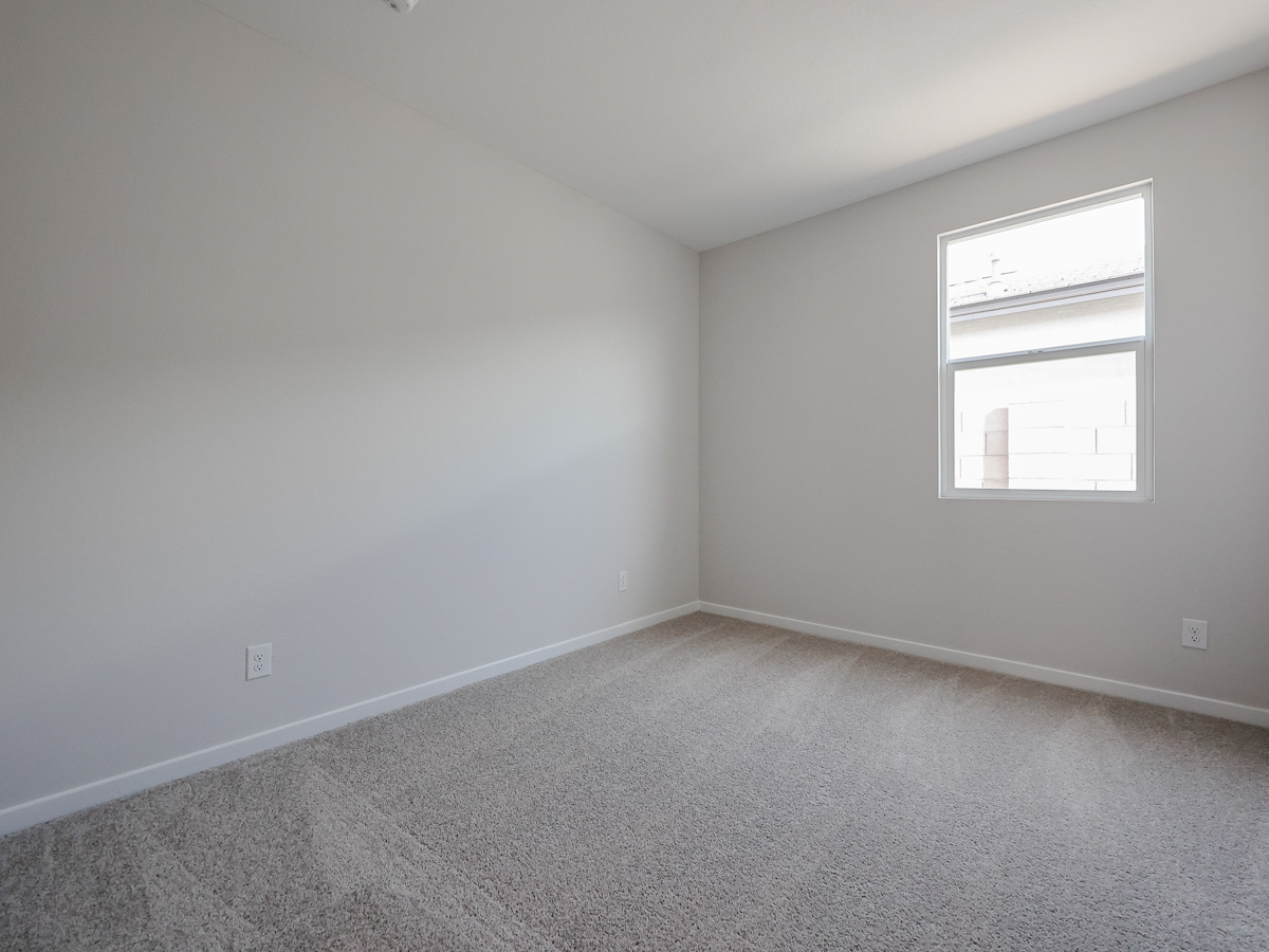 A room with a window and carpet.