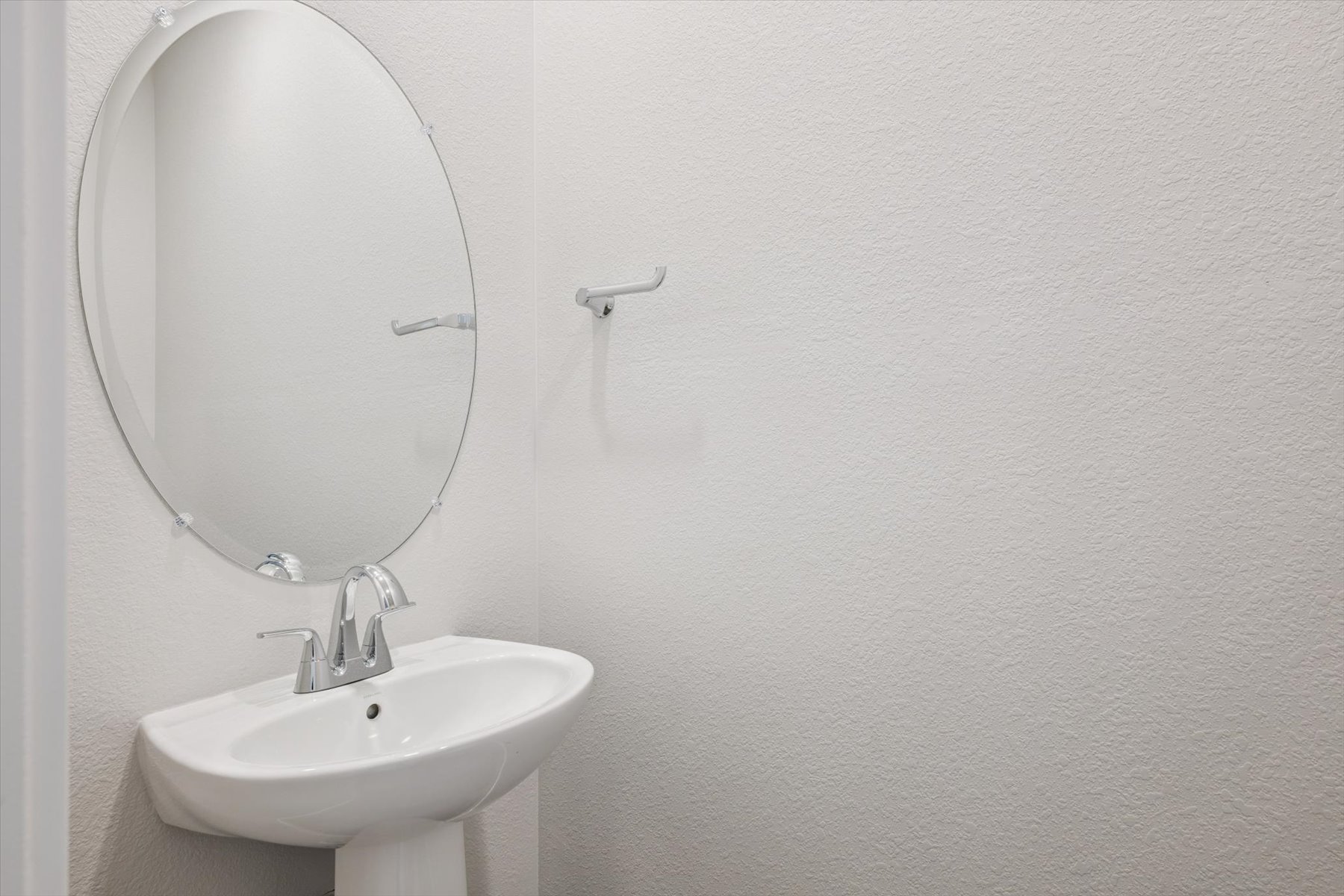 A bathroom with a round mirror.