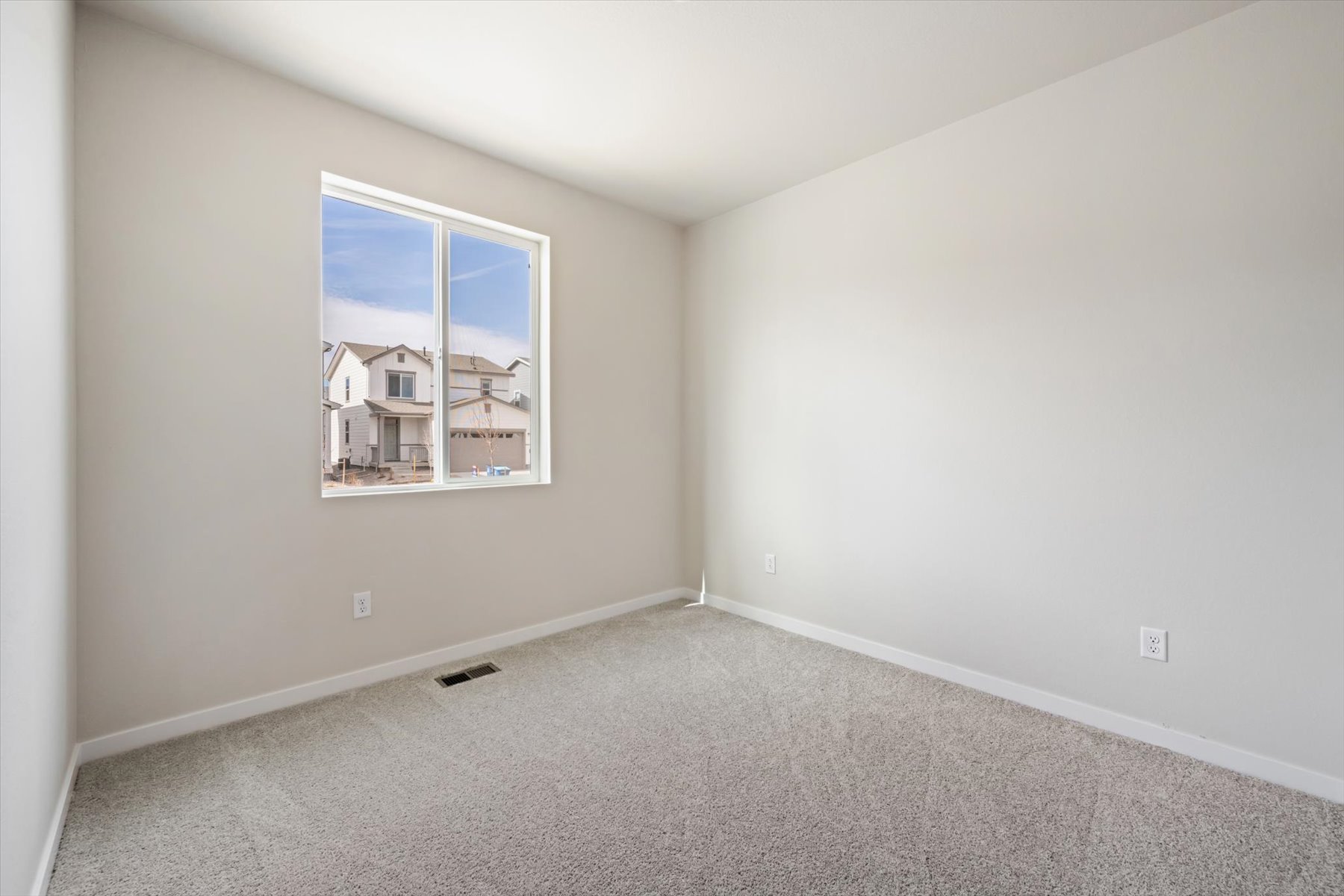 A room with a window and carpet.
