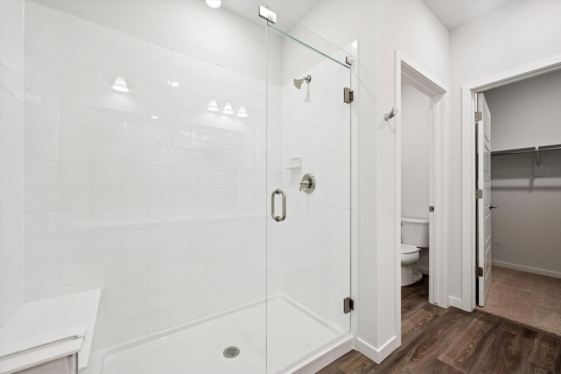 A bathroom with a shower unit and toilet.