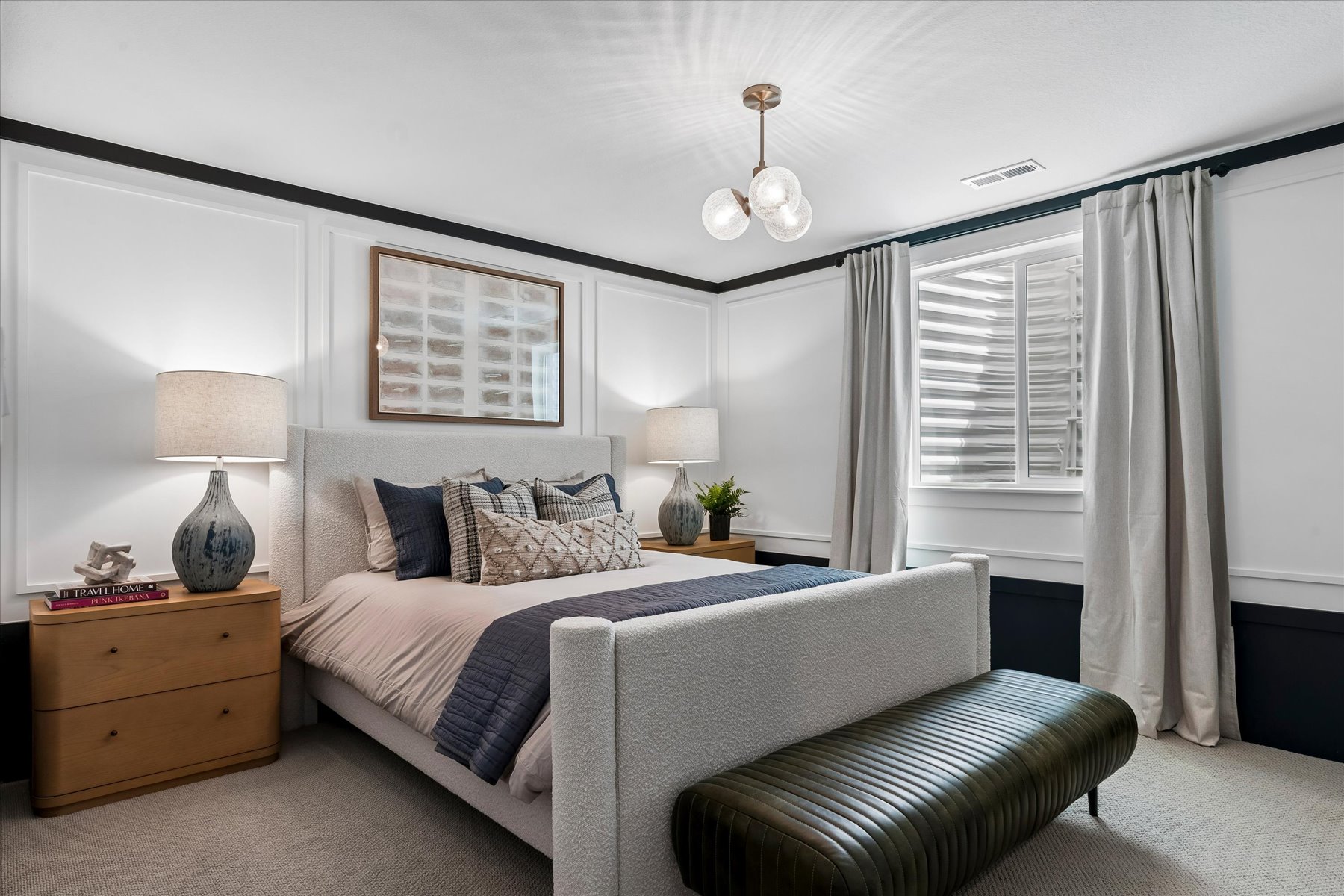A bedroom with a bed and lamps.