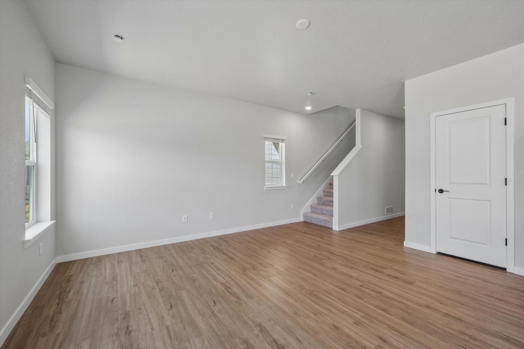 A room with a wood floor and white walls.