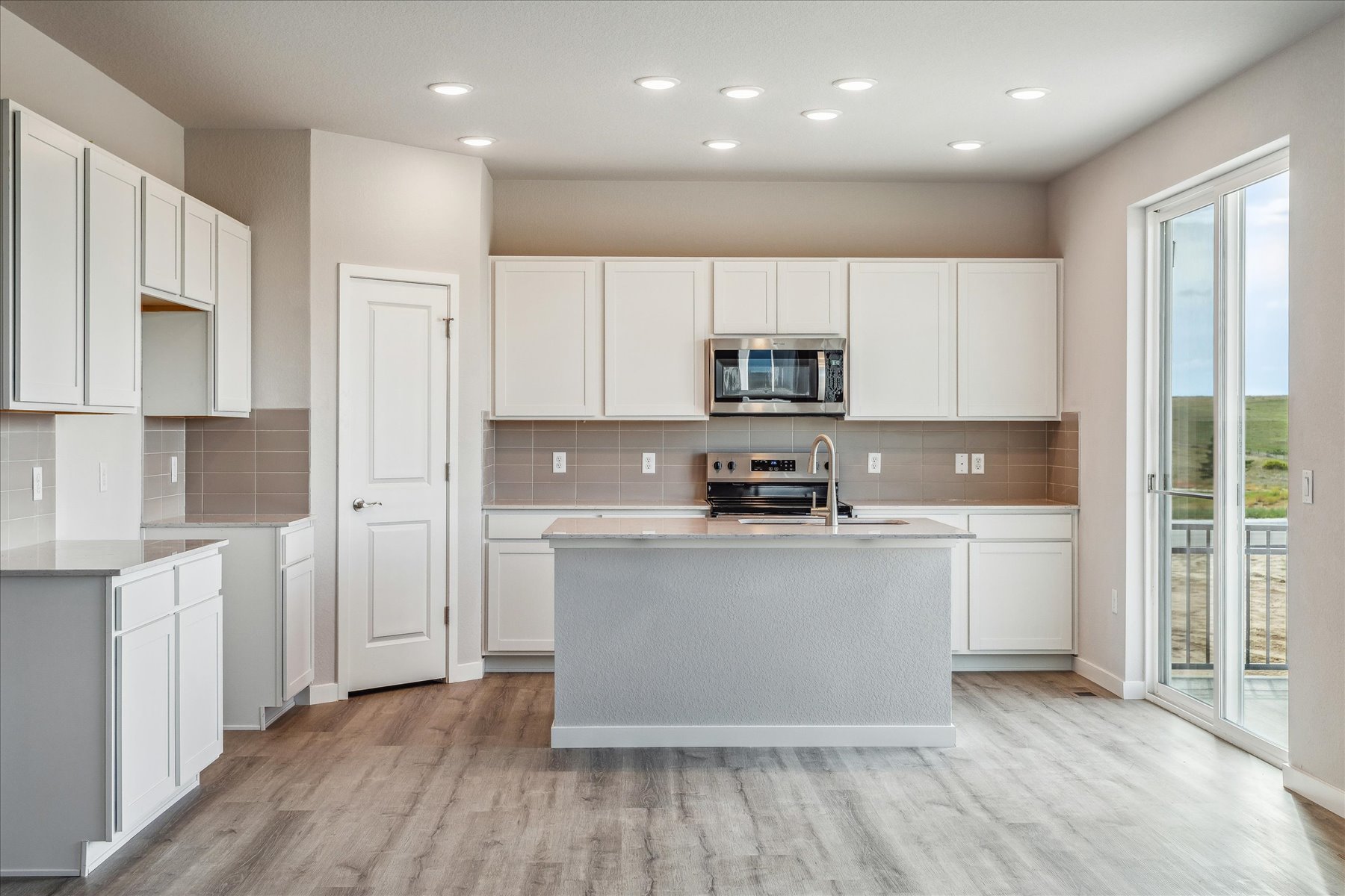 A kitchen with white cabinets.