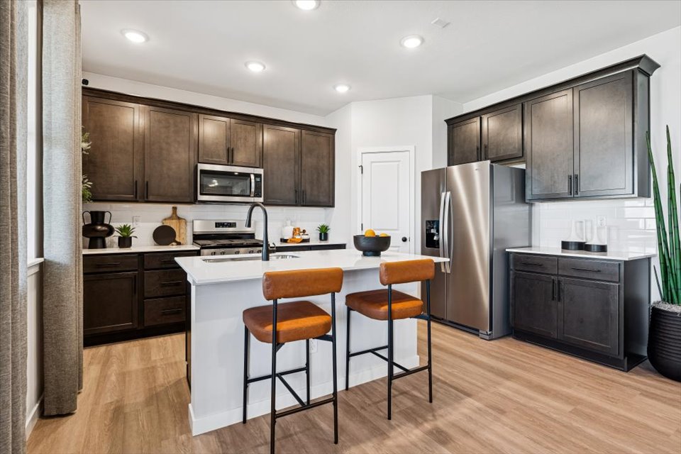 A kitchen with black cabinets.