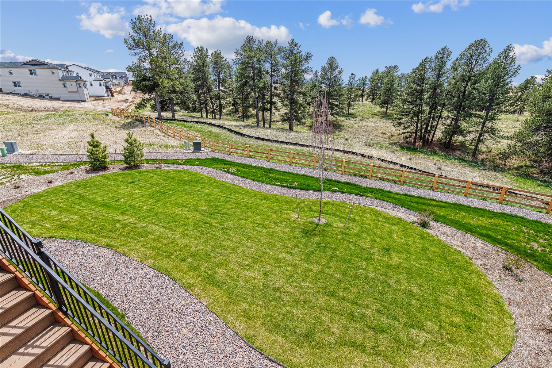 A yard with a fence and trees.