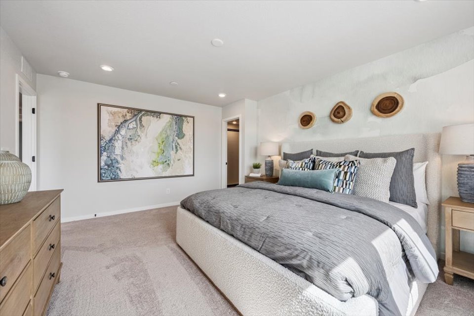 A bedroom with a bed and a painting on the wall.