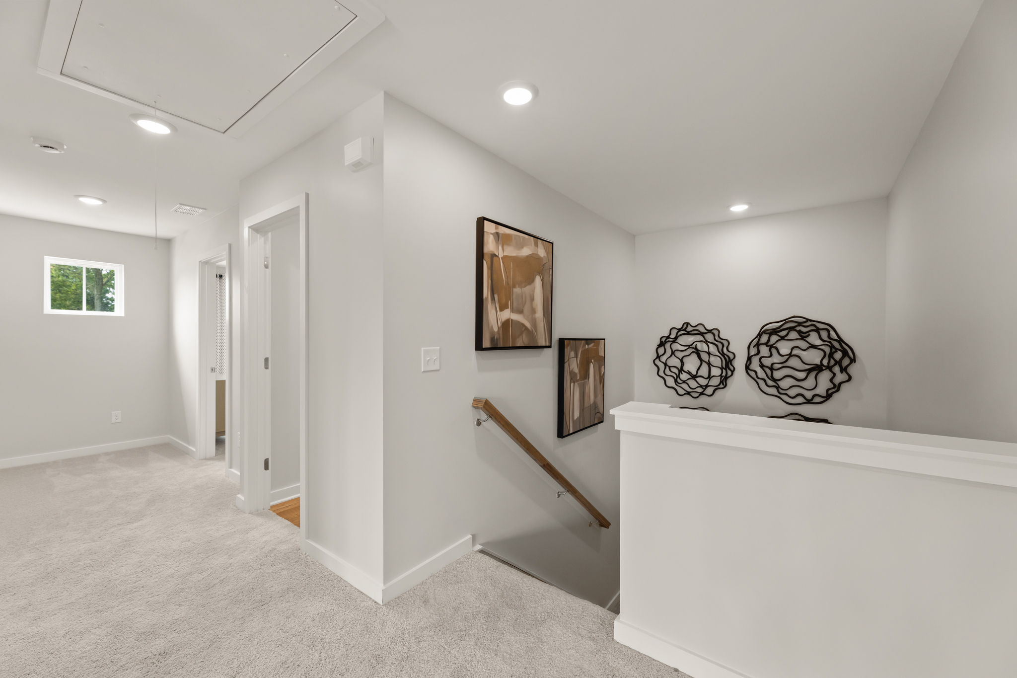 A room with a white wall and a white staircase.