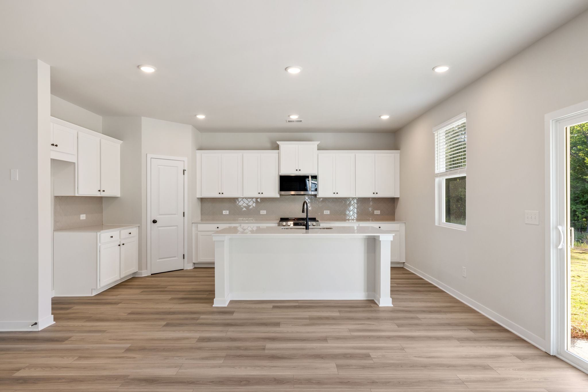 A kitchen with white cabinets.