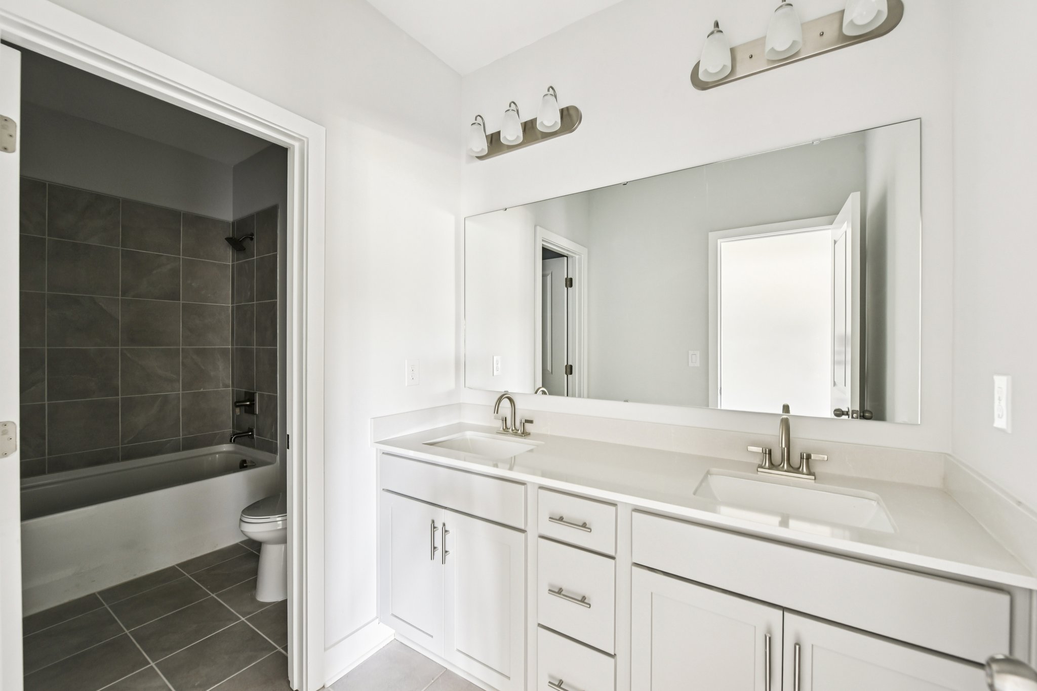 A bathroom with a tub sink and toilet.
