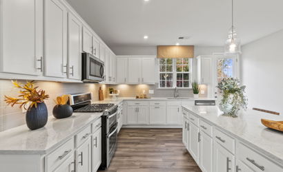 A kitchen with white cabinets.
