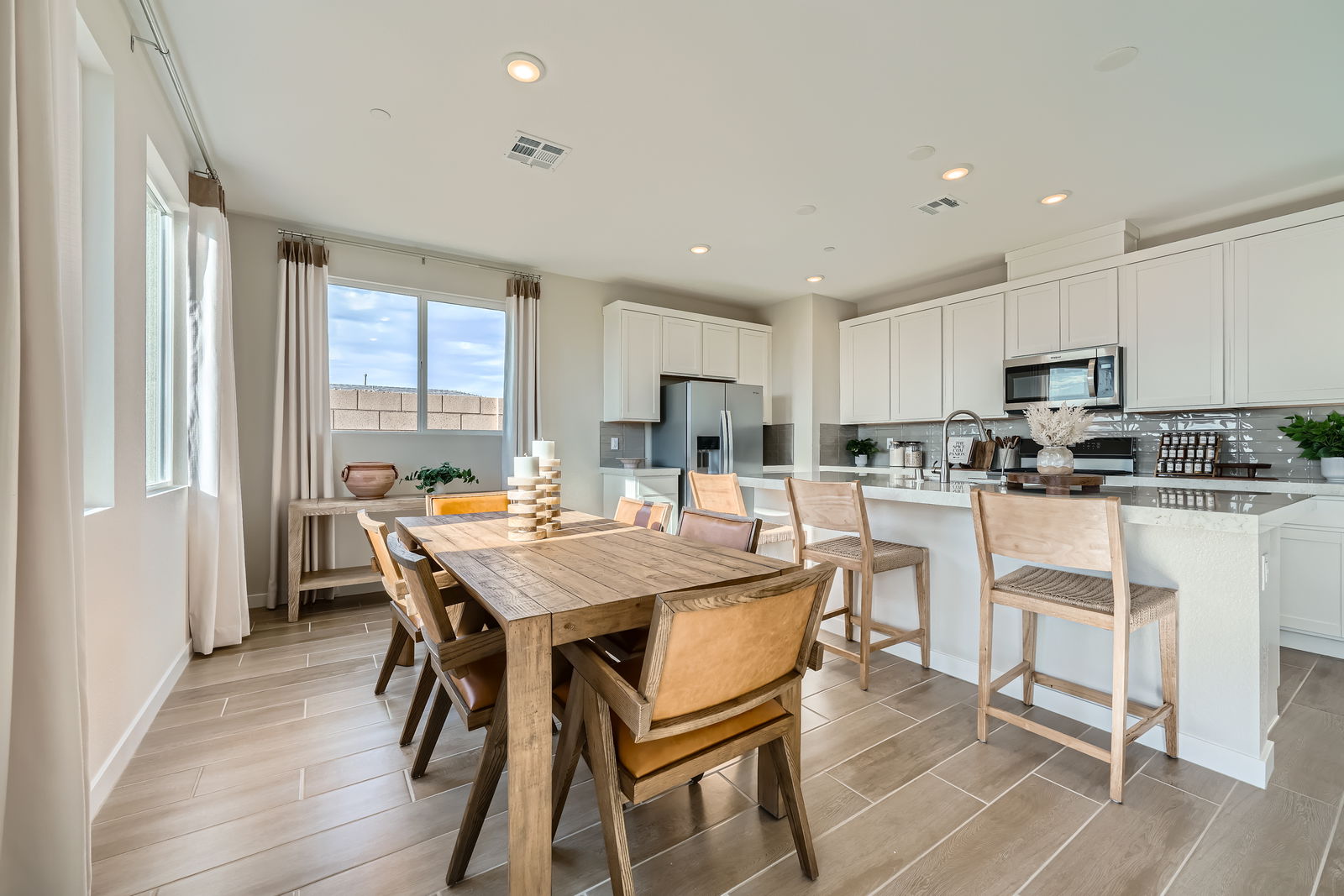 A kitchen with a dining table and chairs.