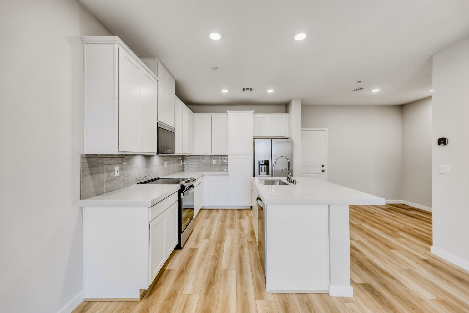 A kitchen with white cabinets.