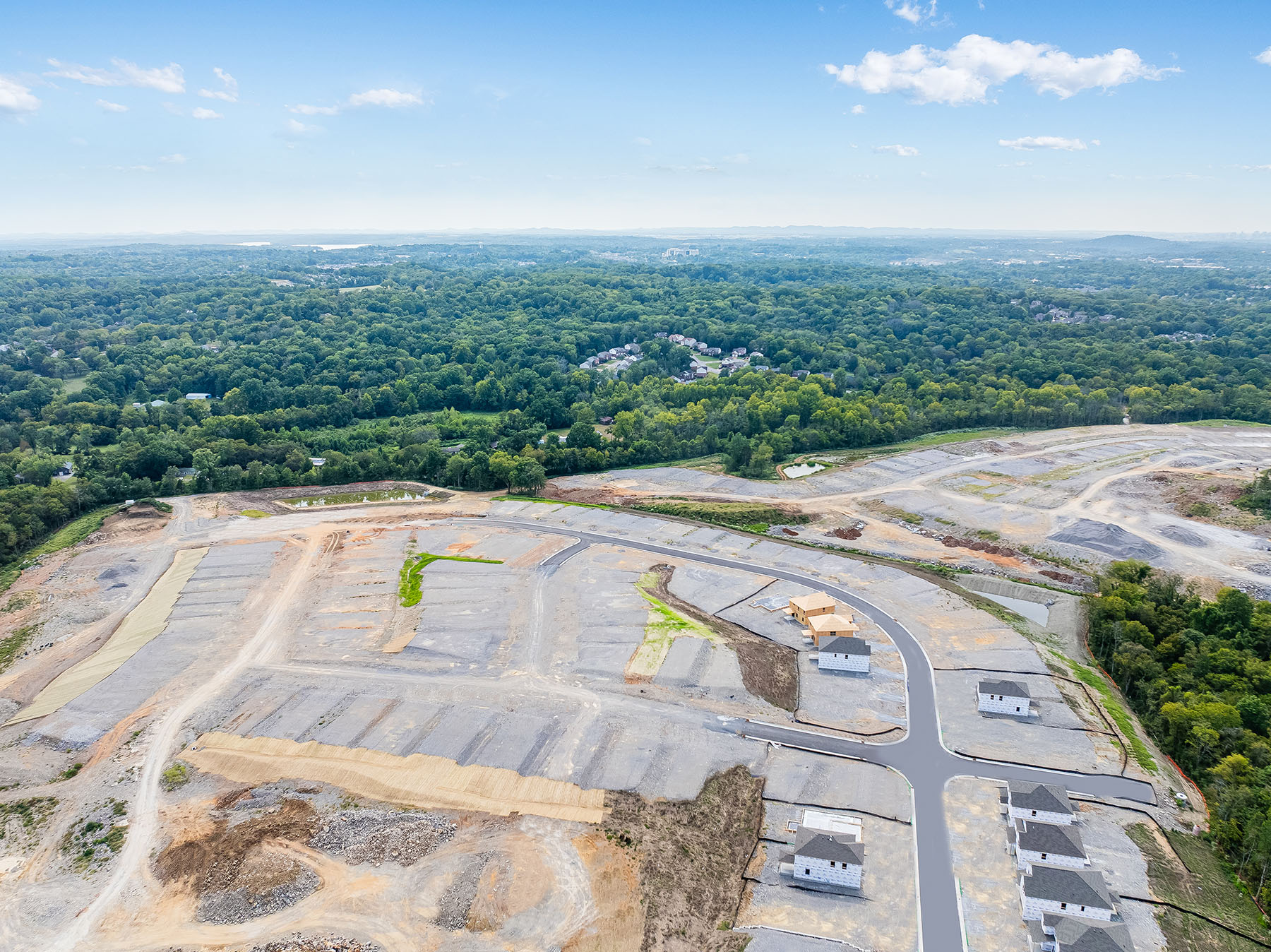 A large area with a road and trees in the background.