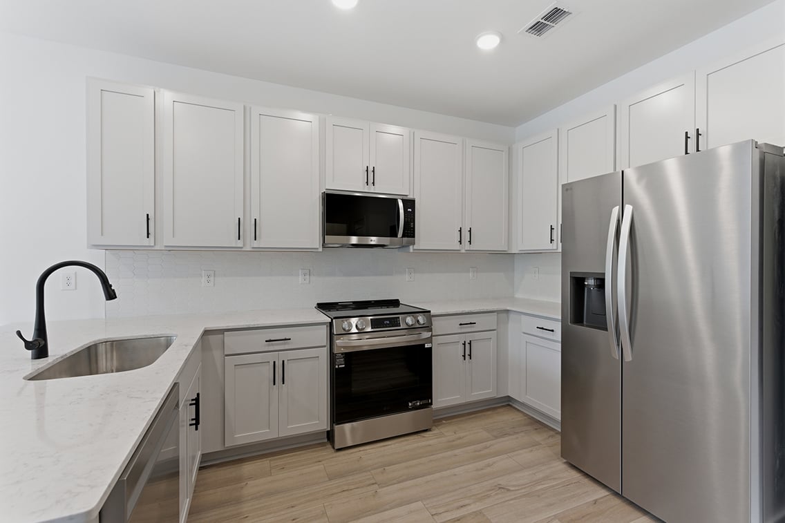 A kitchen with white cabinets.