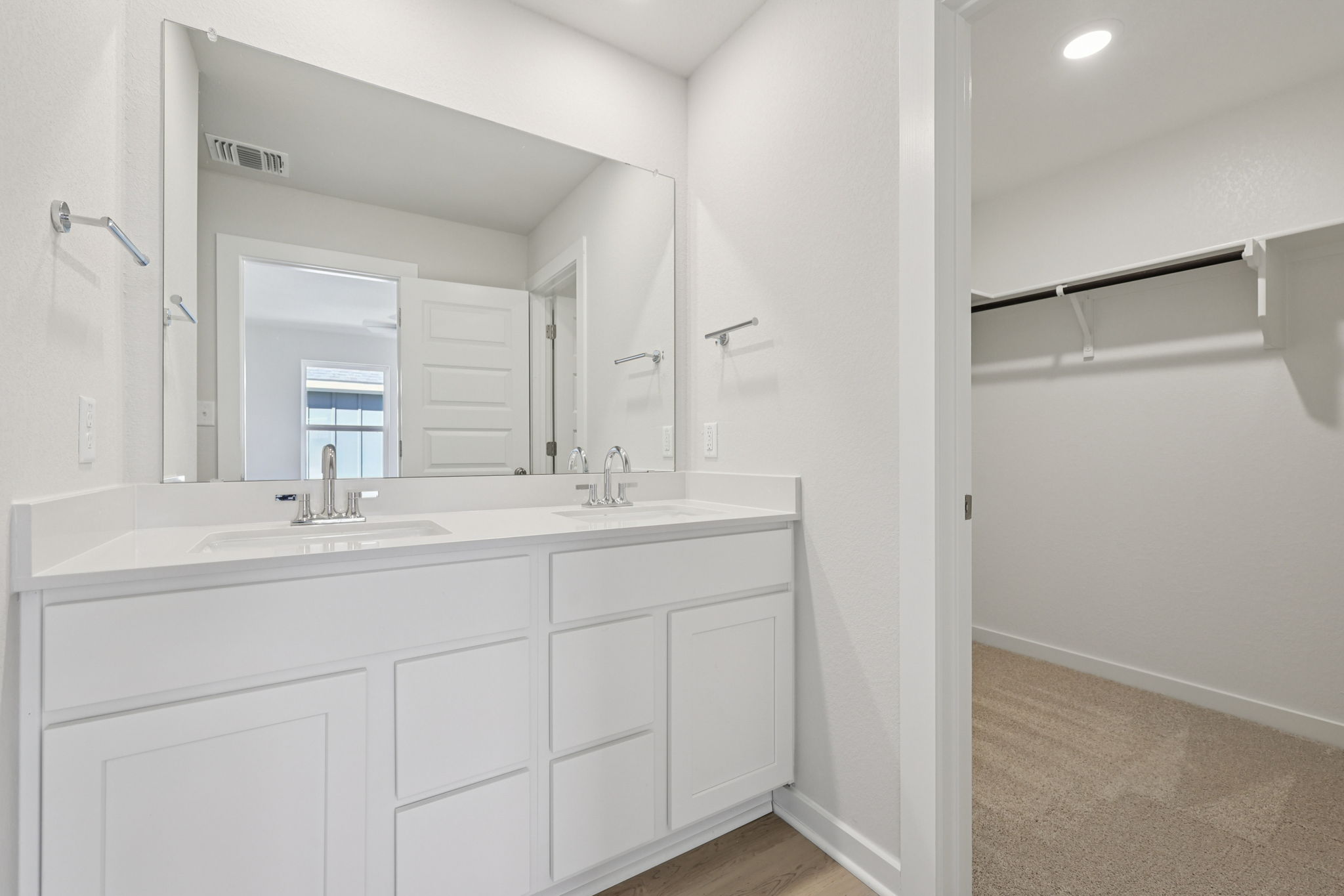 A bathroom with white cabinets.