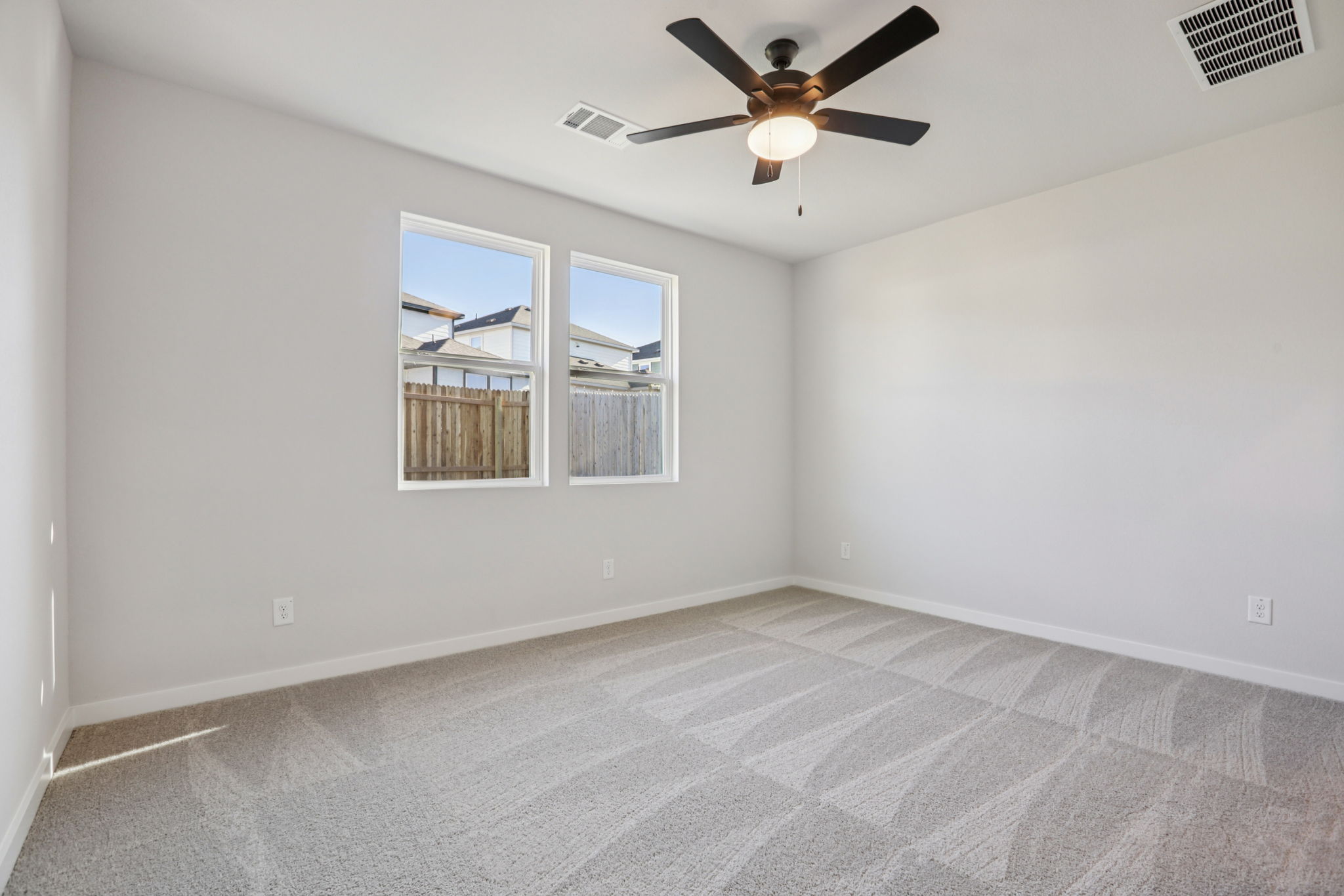 A room with a ceiling fan and a window.