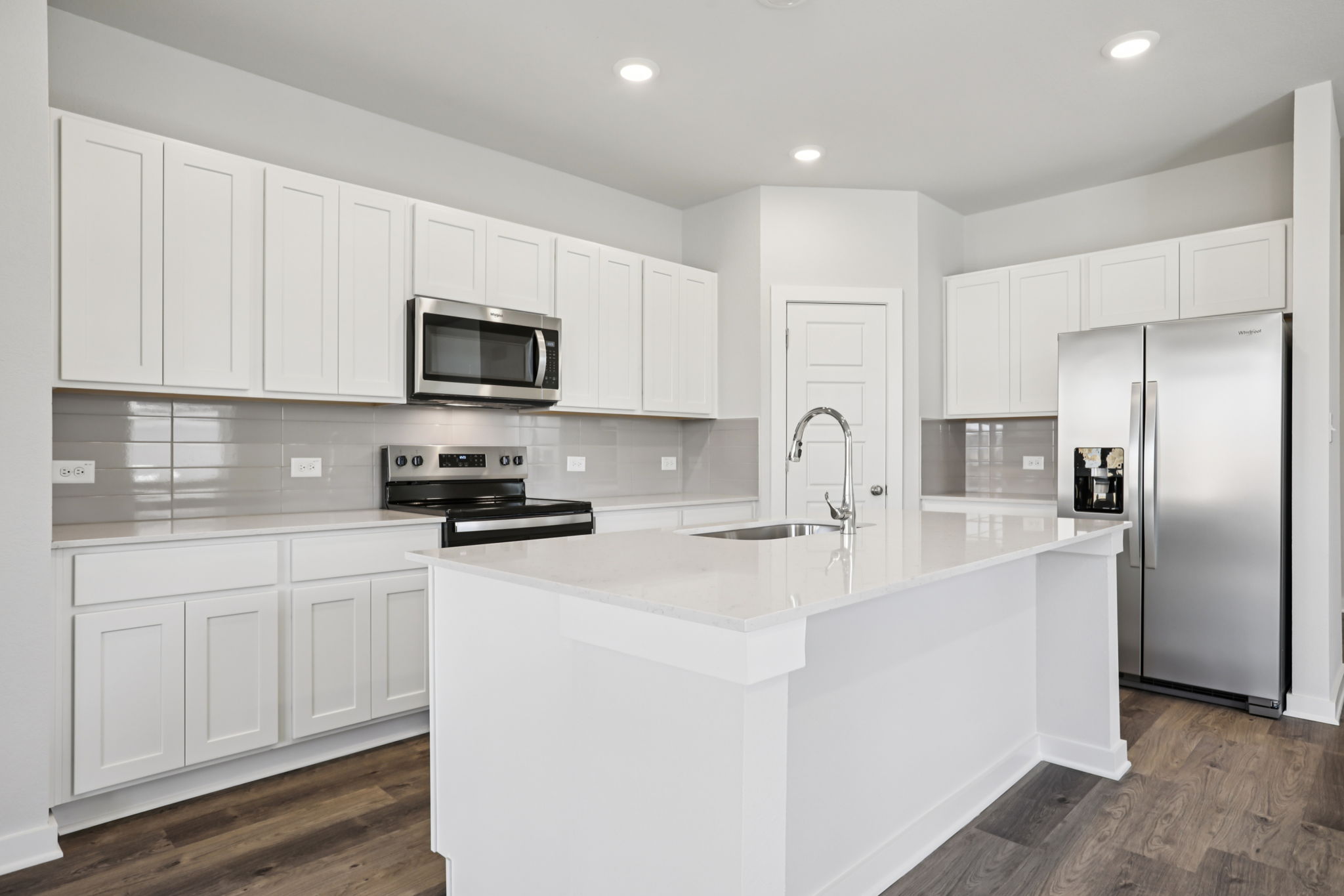 A kitchen with white cabinets.