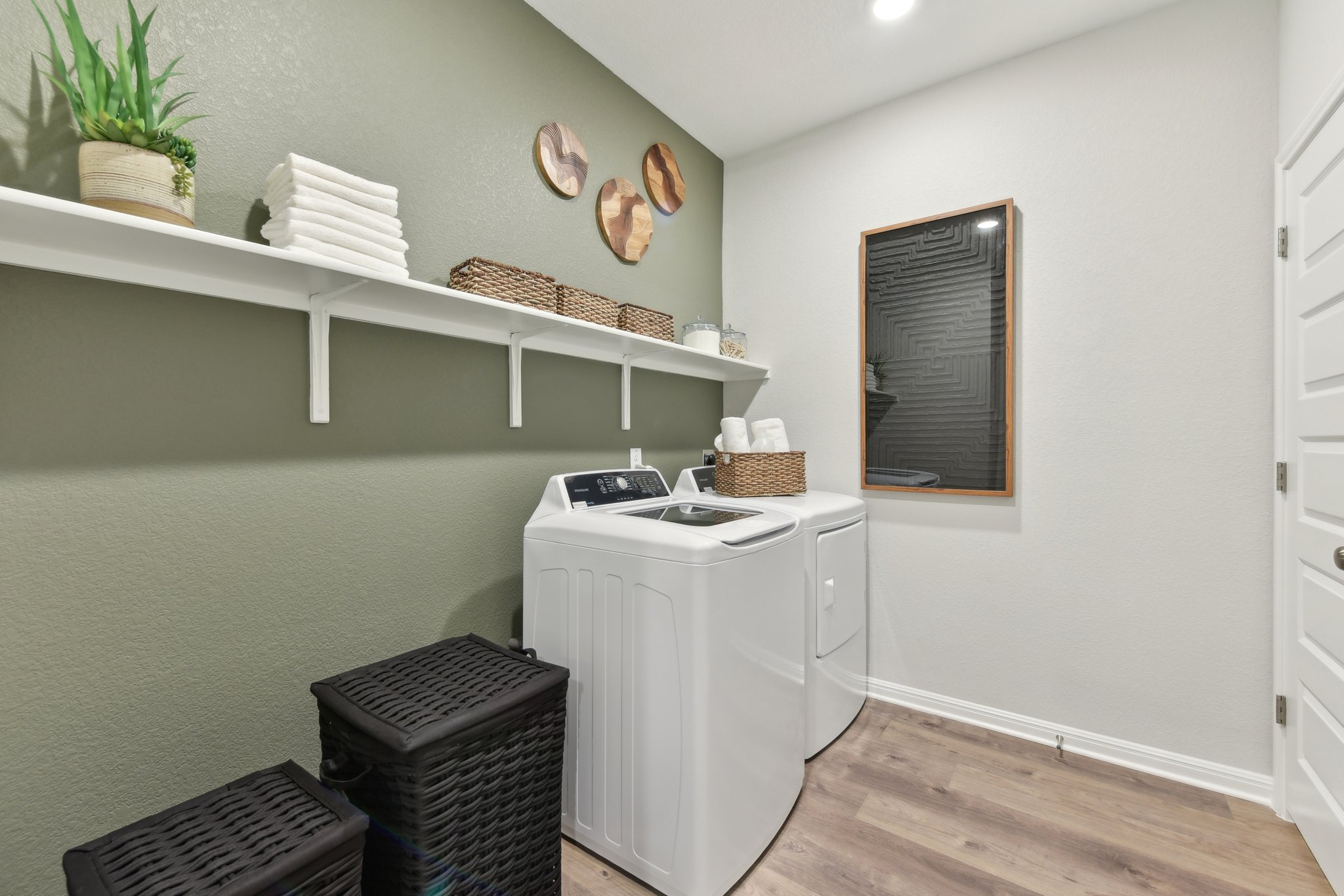 A kitchen with a white stove and shelves.