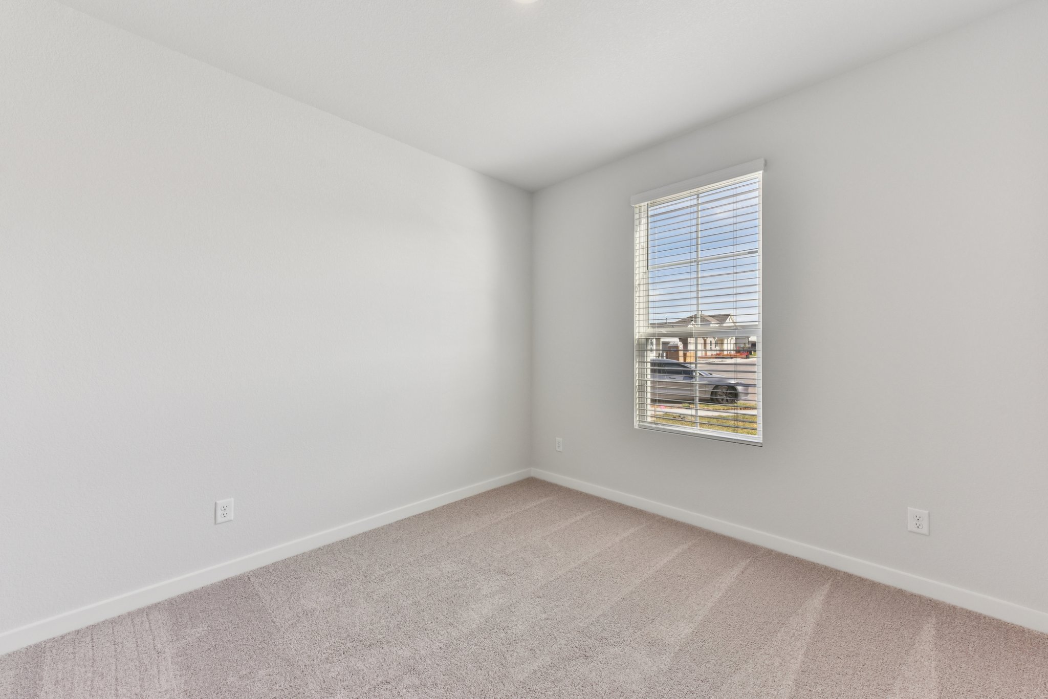 A room with a window and a carpet.