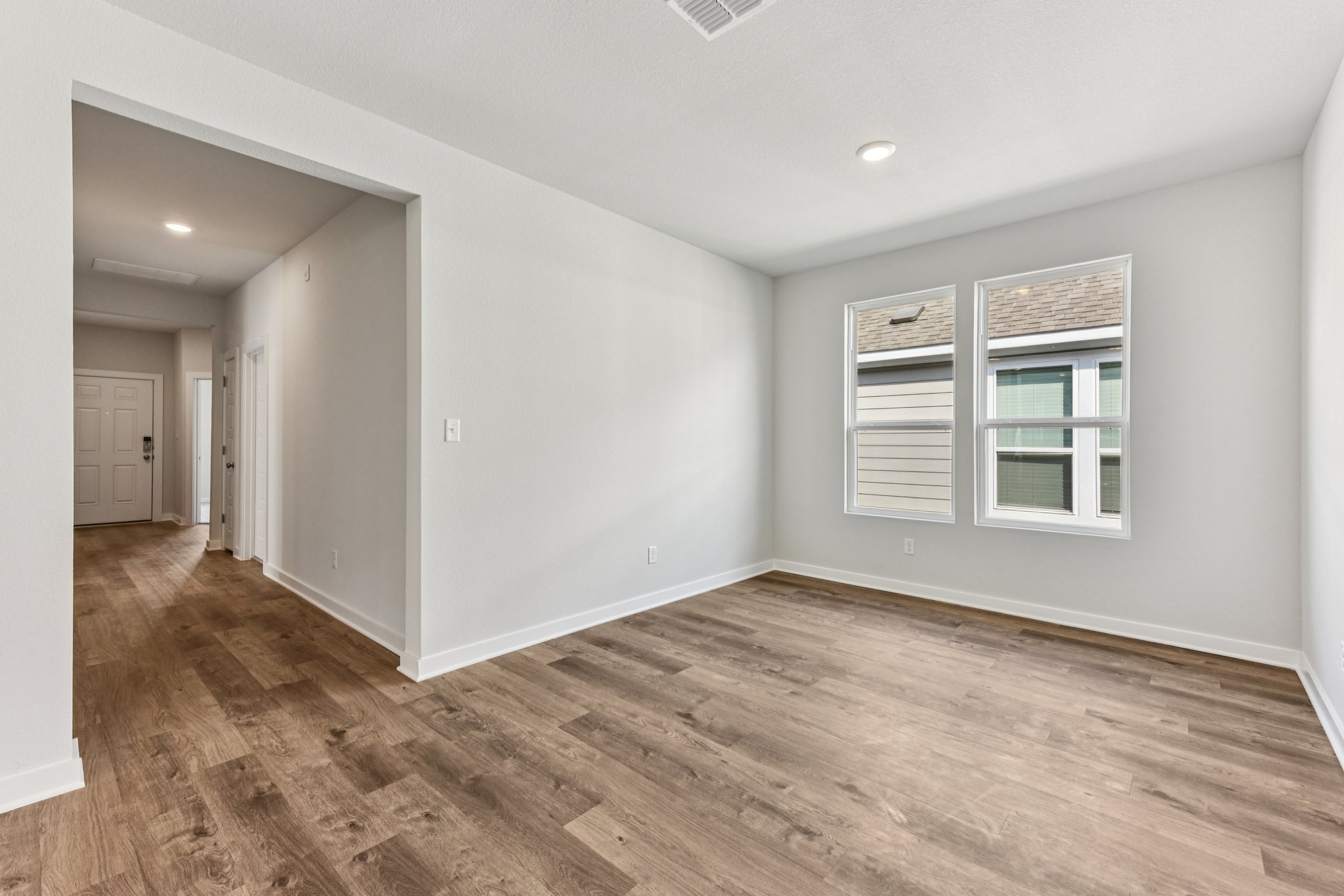 A room with a wood floor and a window.