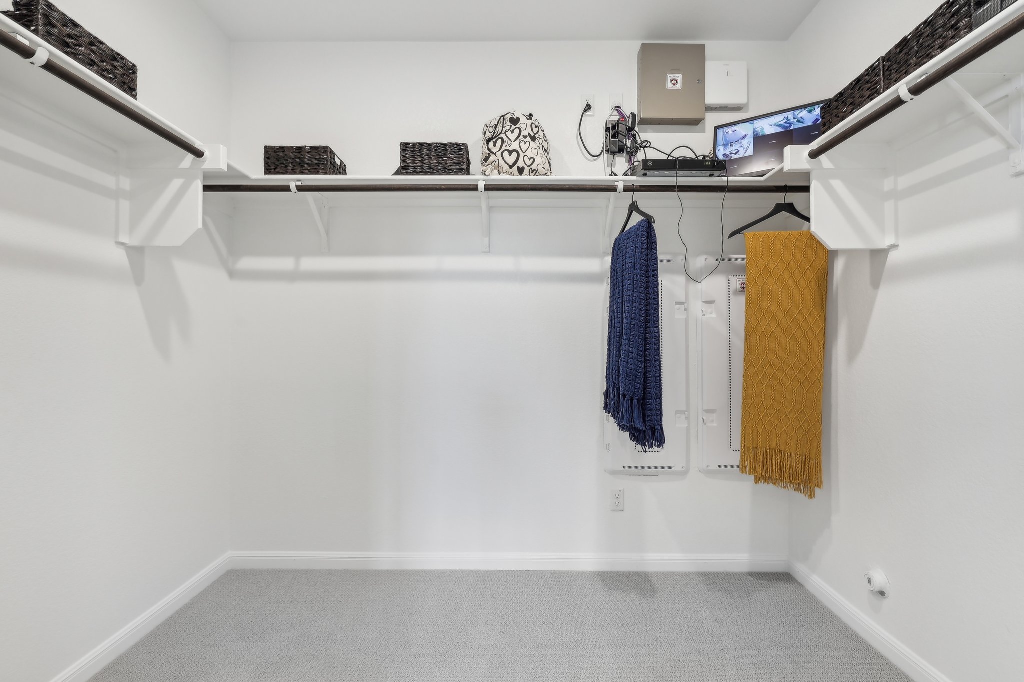 A white room with a shelf and a towel on the wall.