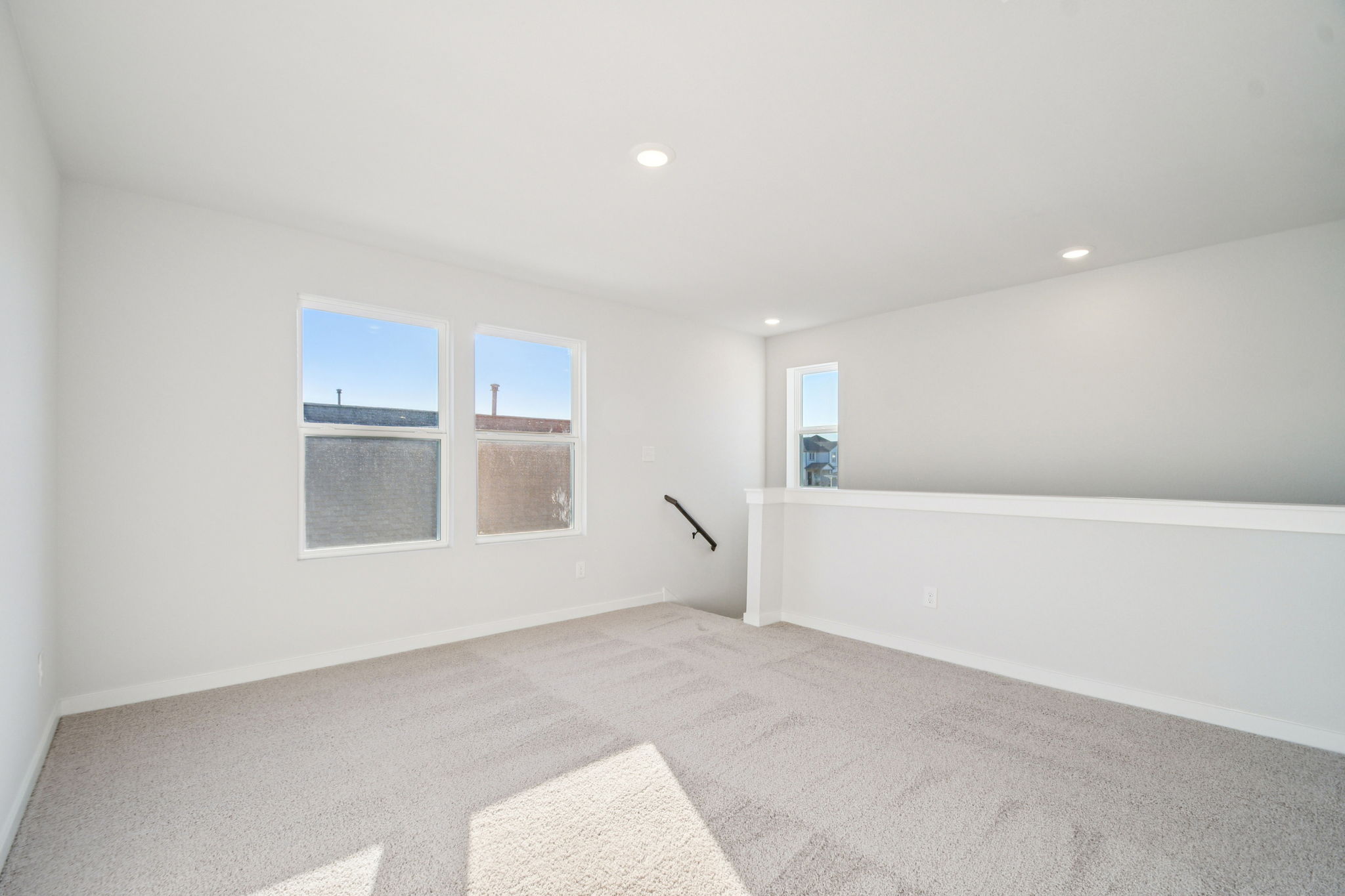 A room with a white couch and a window.