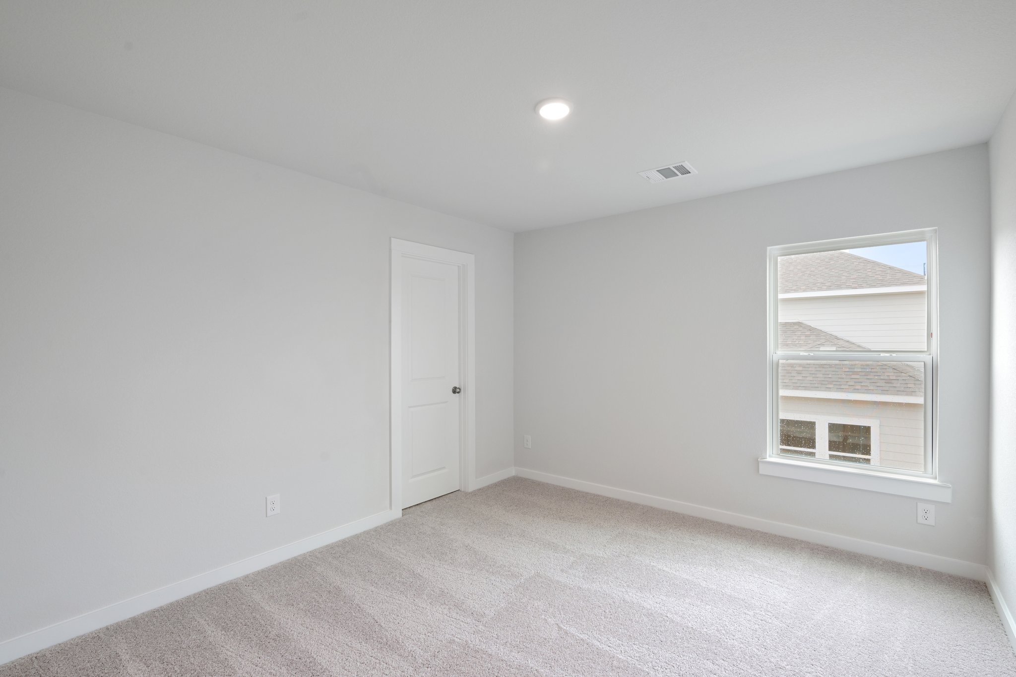 A room with a white door and a white wall.