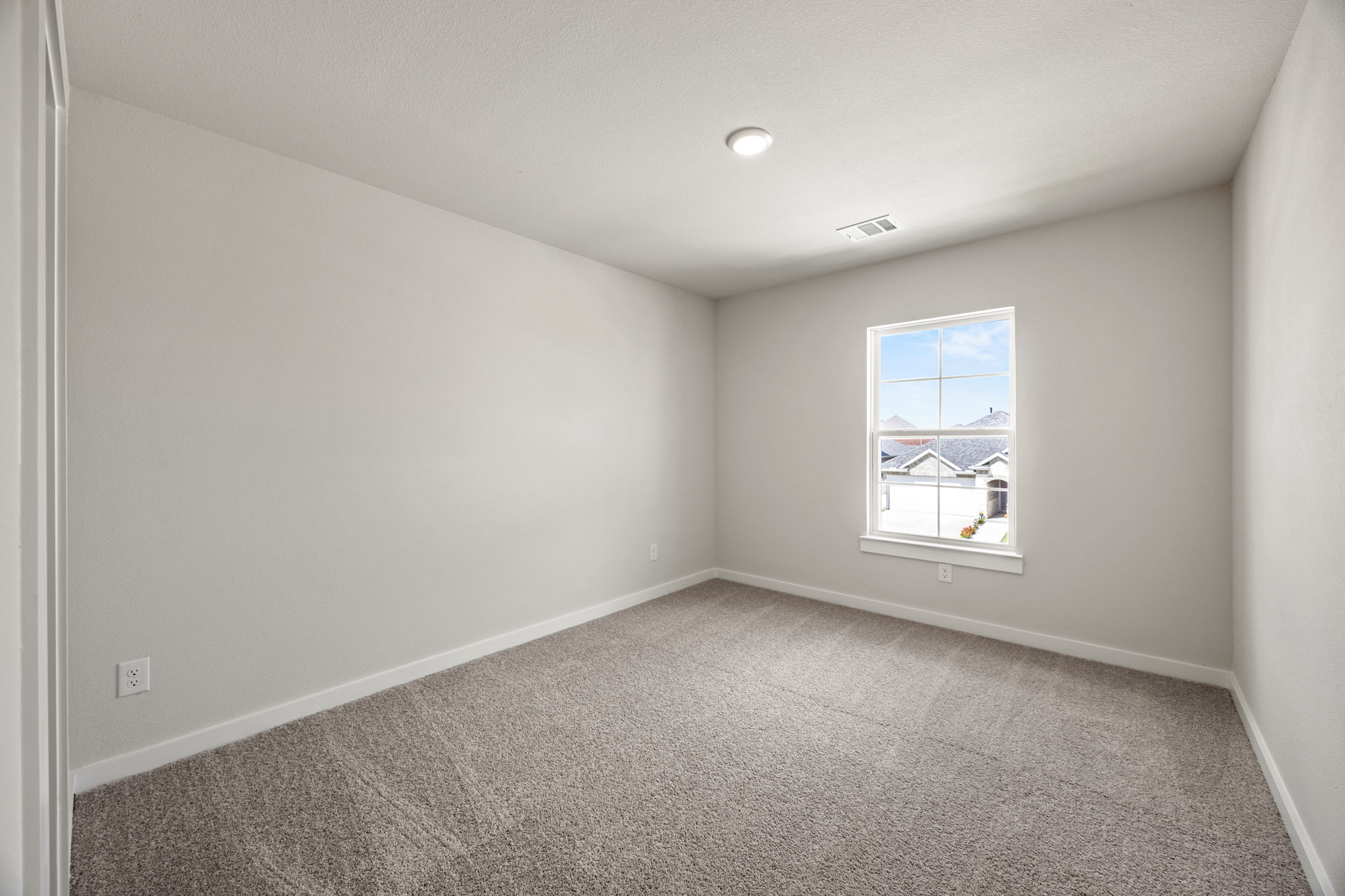A room with a window and carpet.