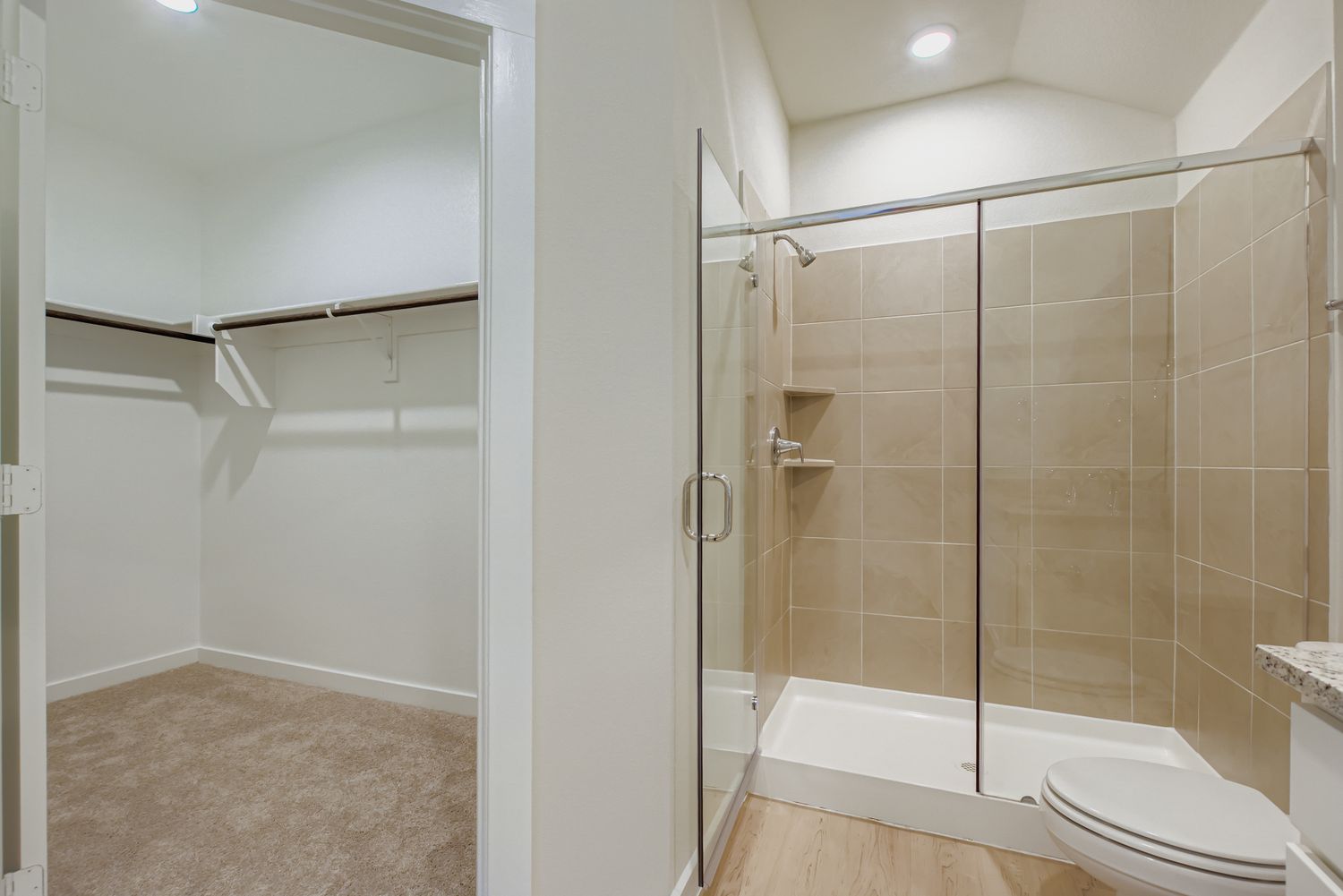 A bathroom with a shower unit and toilet.
