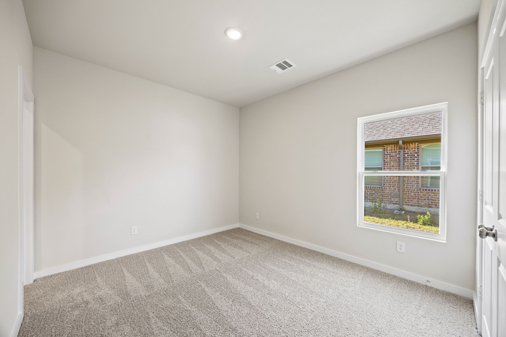 A room with a window and a carpet.