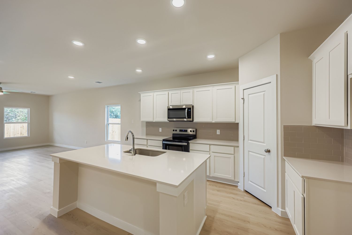 A kitchen with white cabinets.