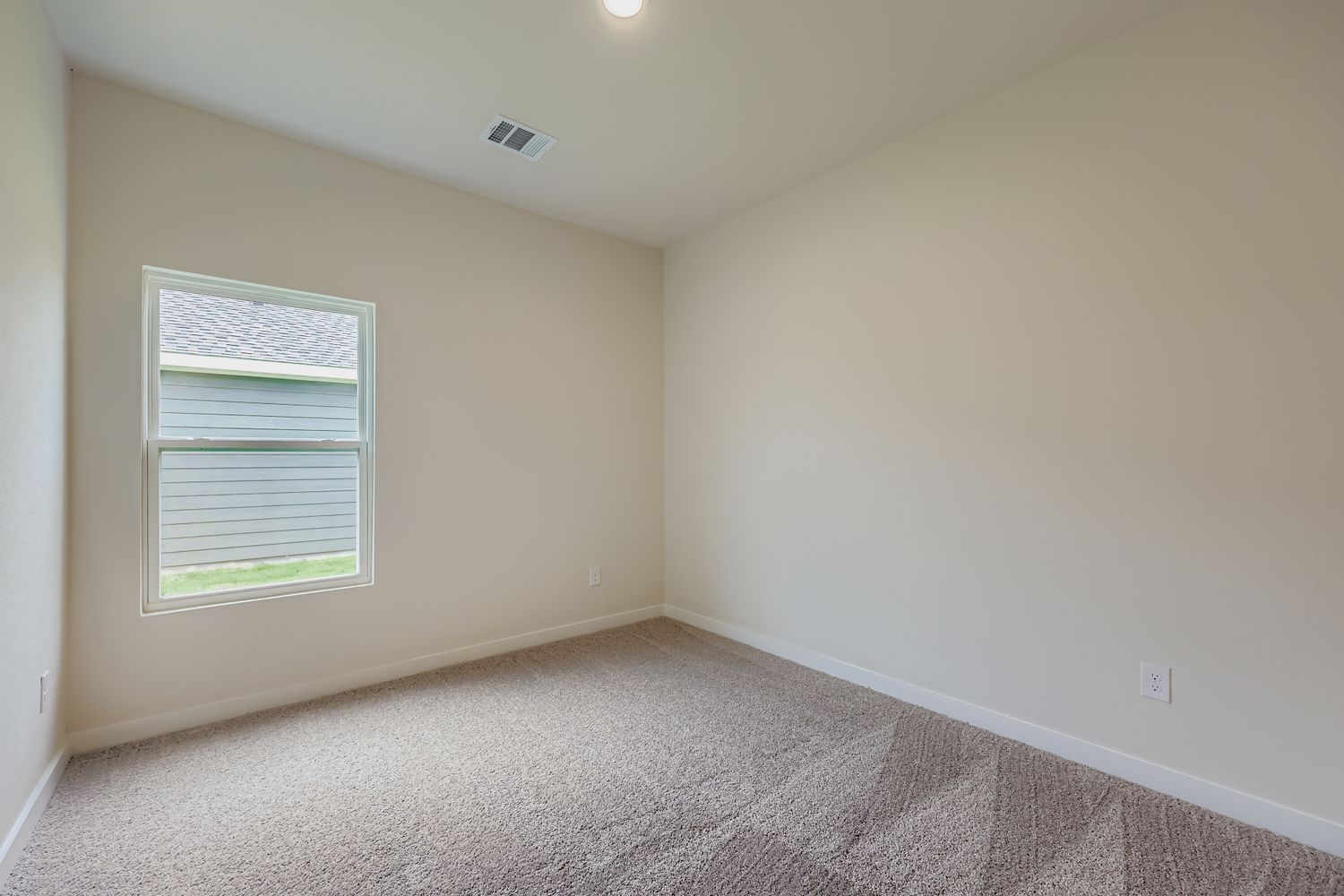 A room with a carpet and a window.