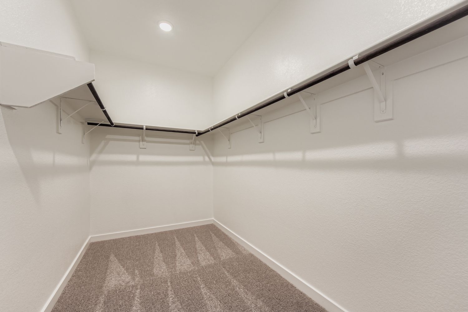 A white hallway with a metal railing.