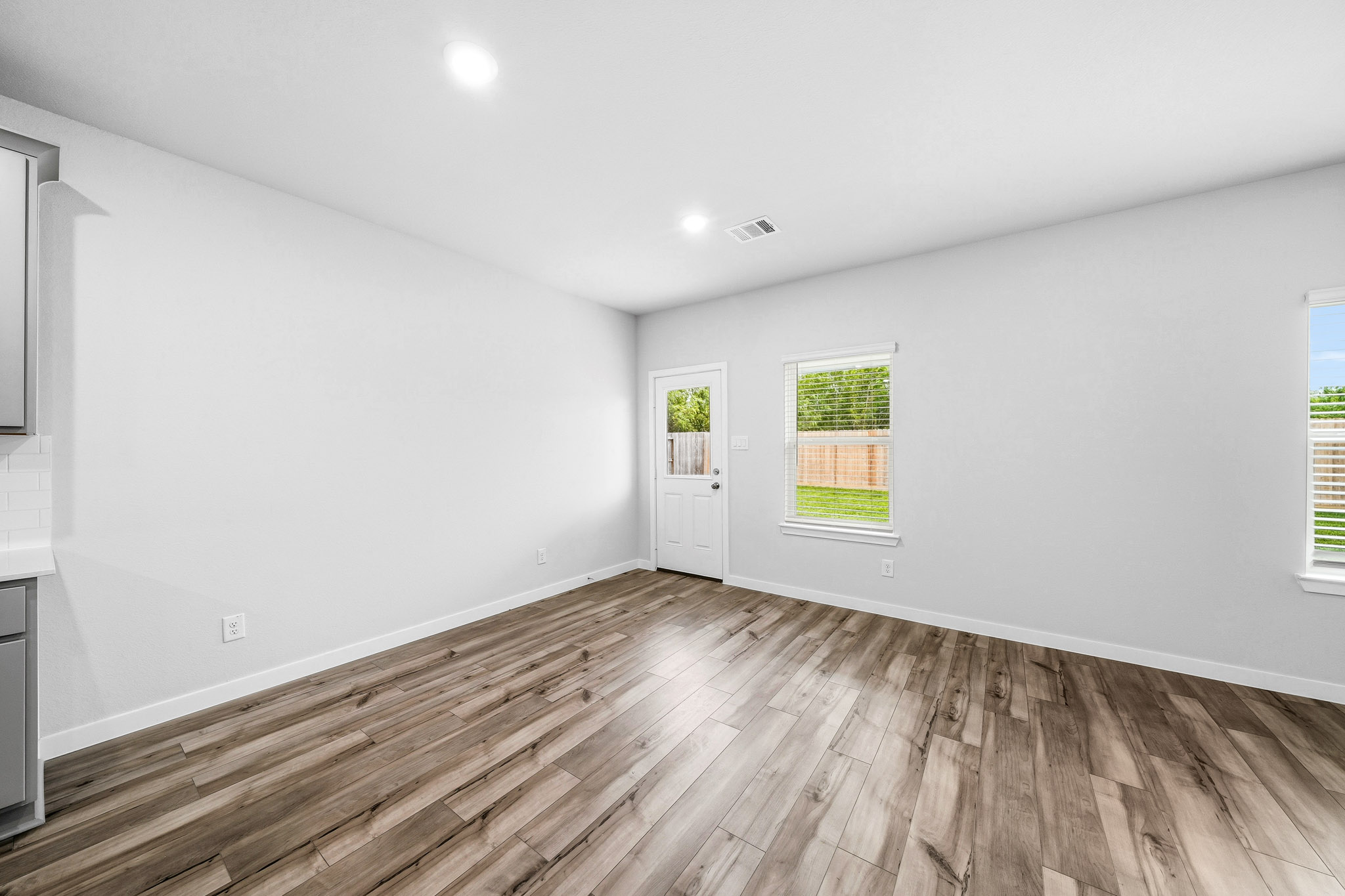 A room with a wood floor and windows.