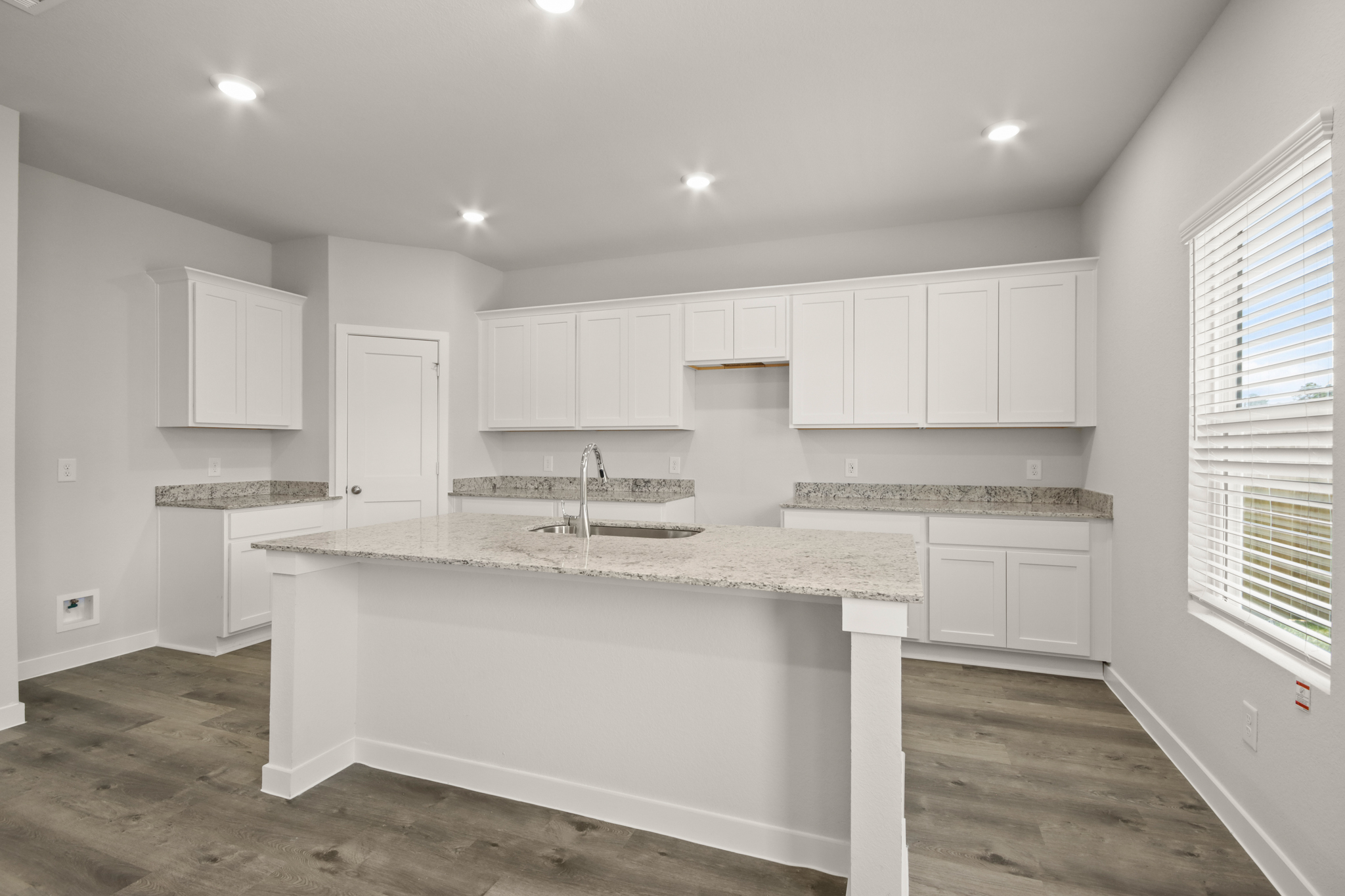 A kitchen with white cabinets.