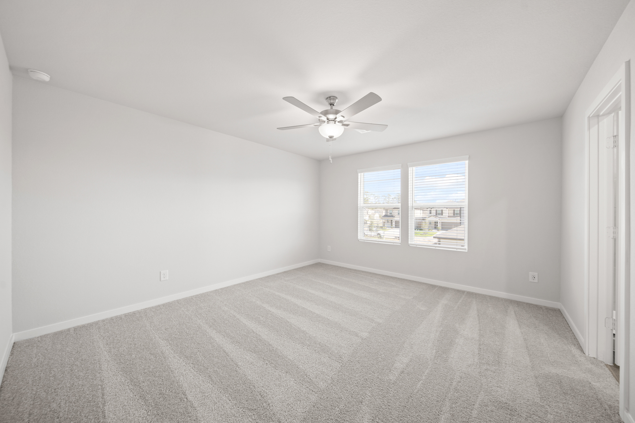A room with a ceiling fan and a window.