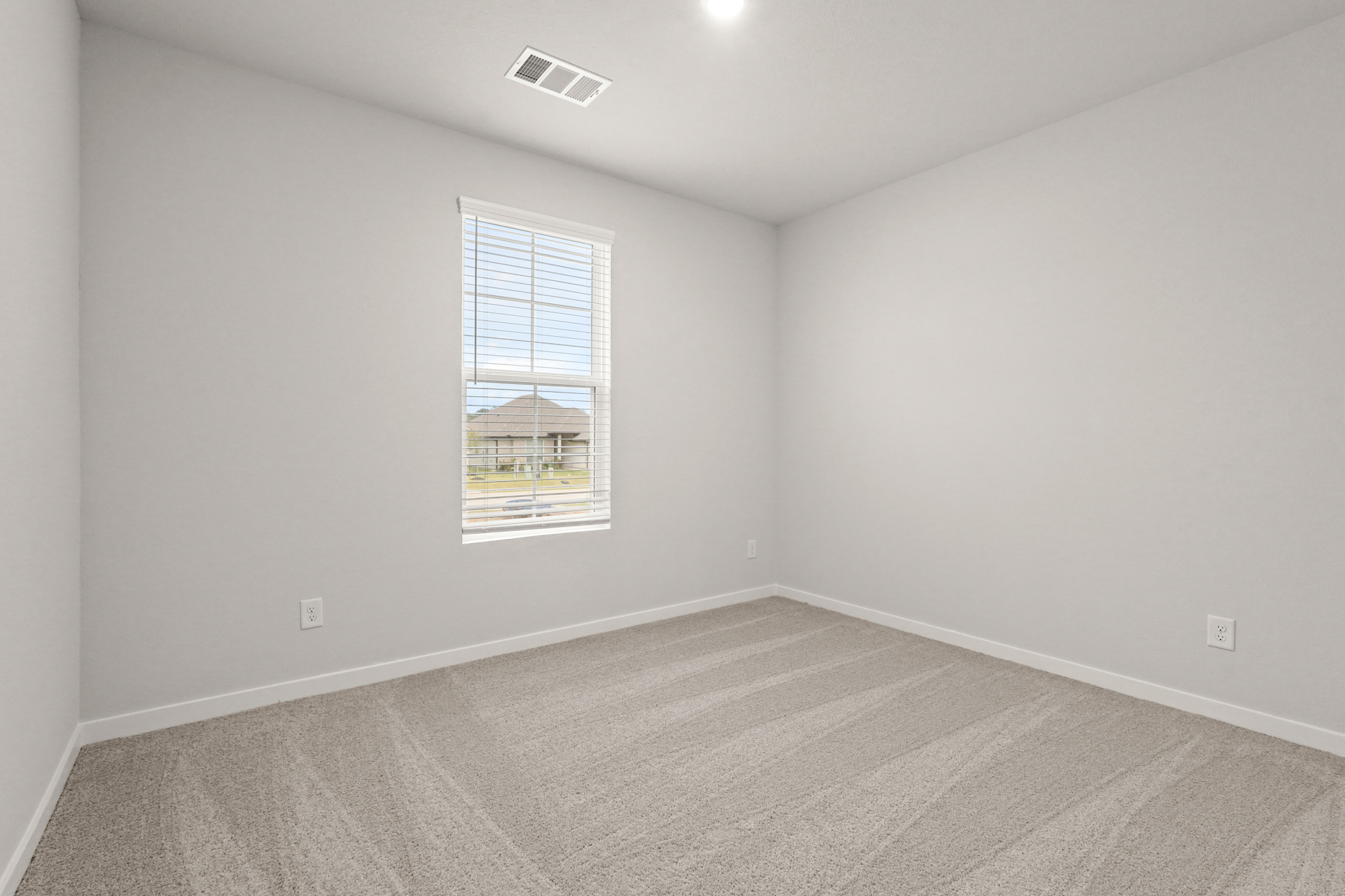 A room with a window and a carpet.