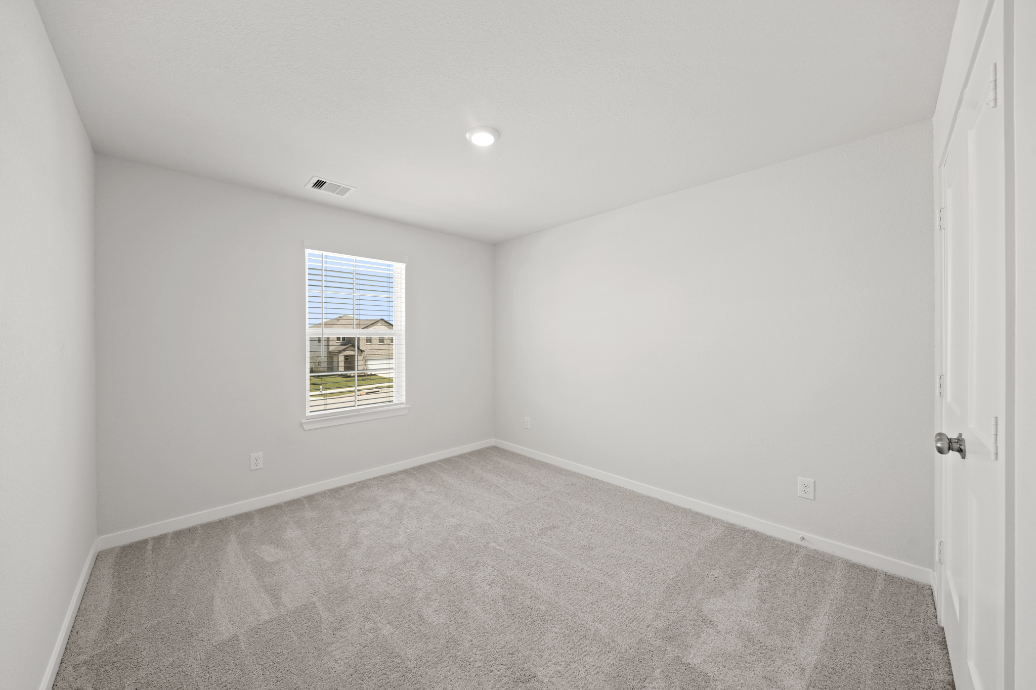 A room with a carpet and a window.