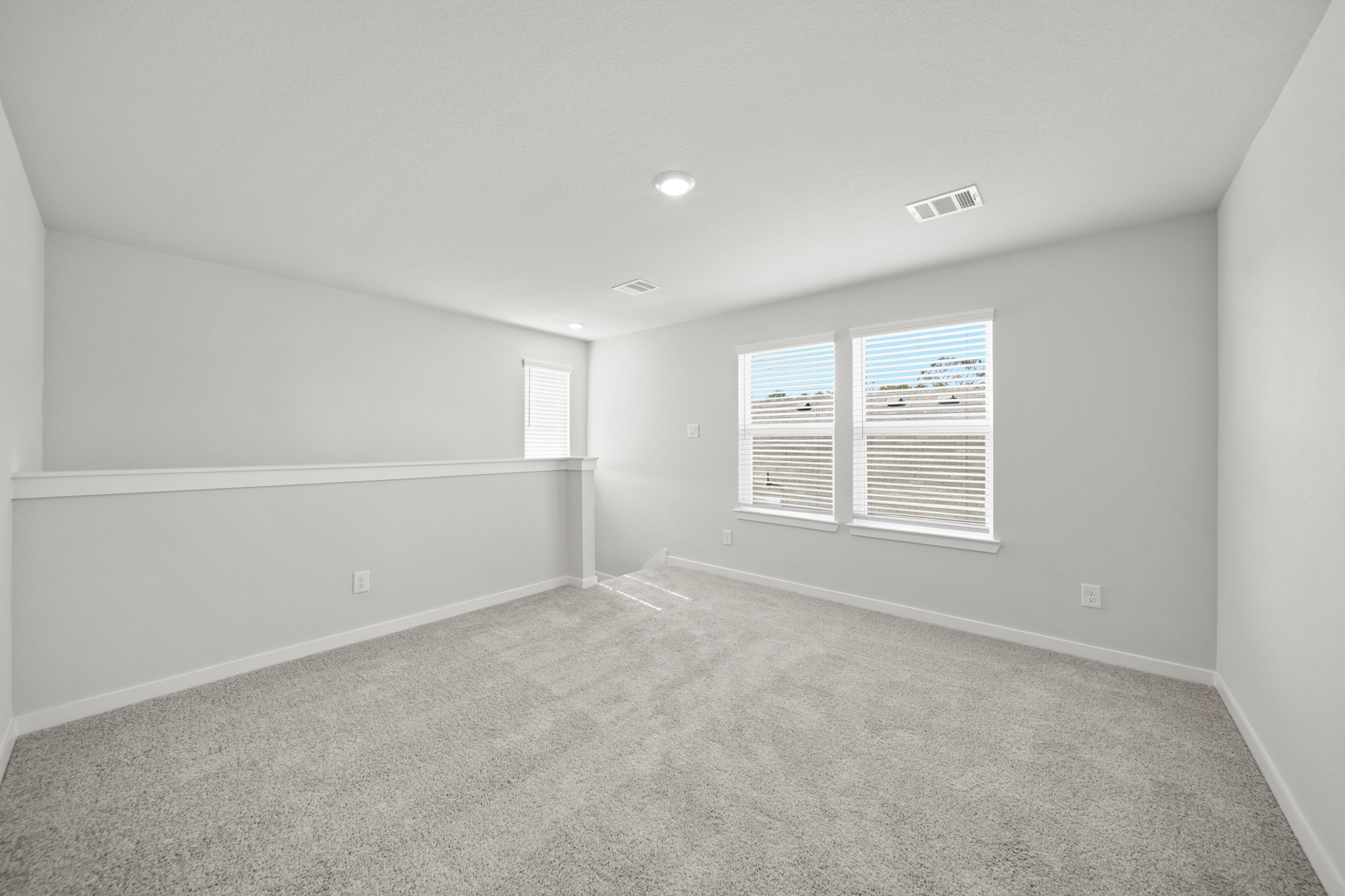 A room with a carpet and windows.